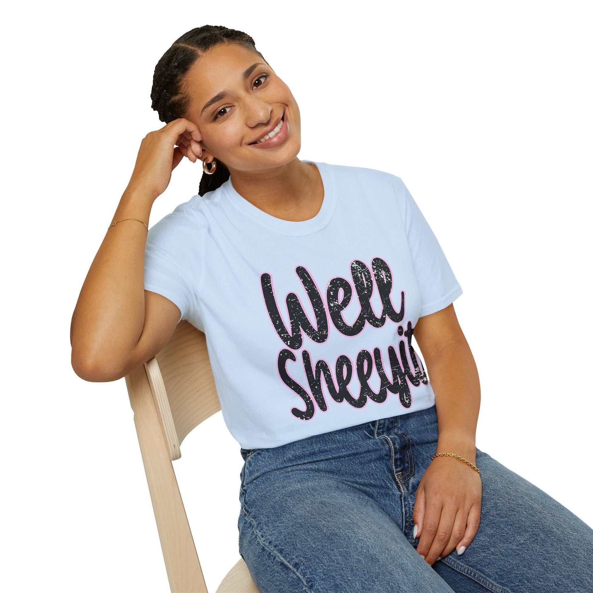 Woman wearing light blue casual statement tee with "Well Sheeyit" funny quote sitting on chair