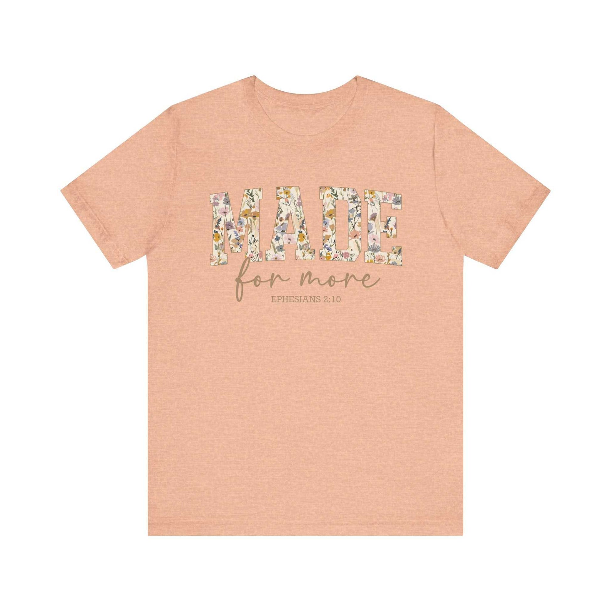 Unisex peach "Made for More" floral print tee with short sleeves and ribbed collar, breathable cotton fabric.