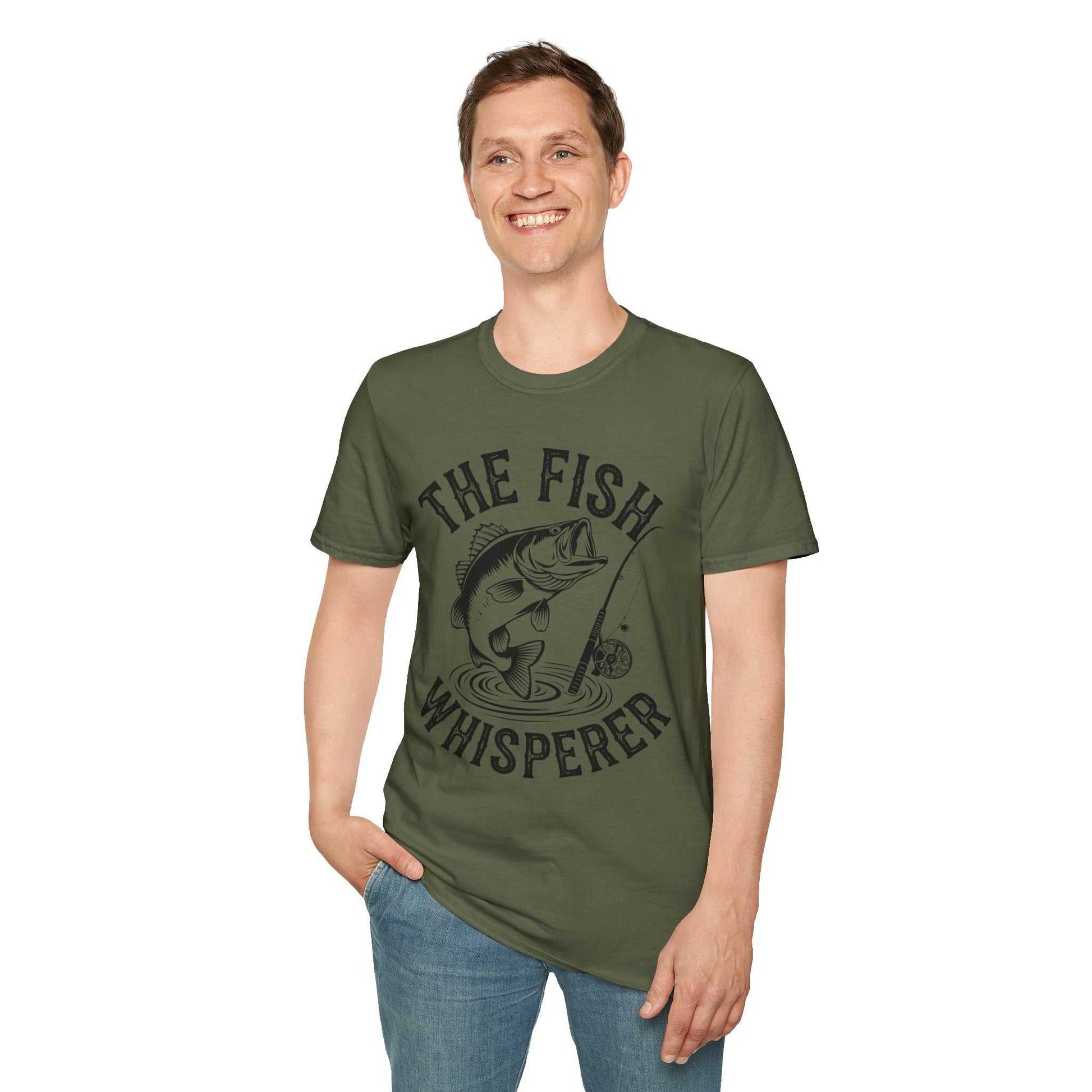 Man wearing olive green unisex softstyle t-shirt with "The Fish Whisperer" fishing graphic design.