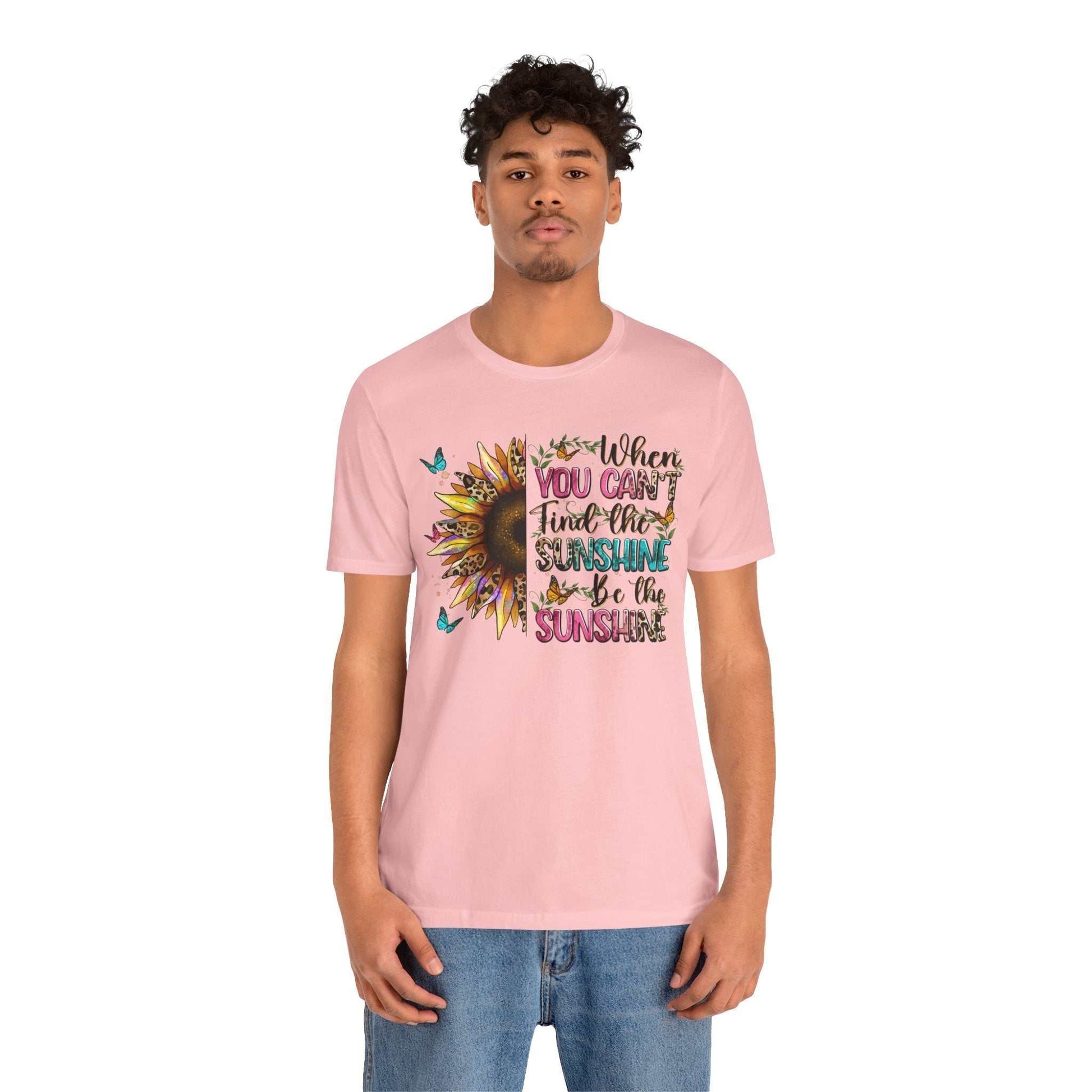 Man wearing pink Sunshine Quote Tee with colorful sunflower and motivational text design on front