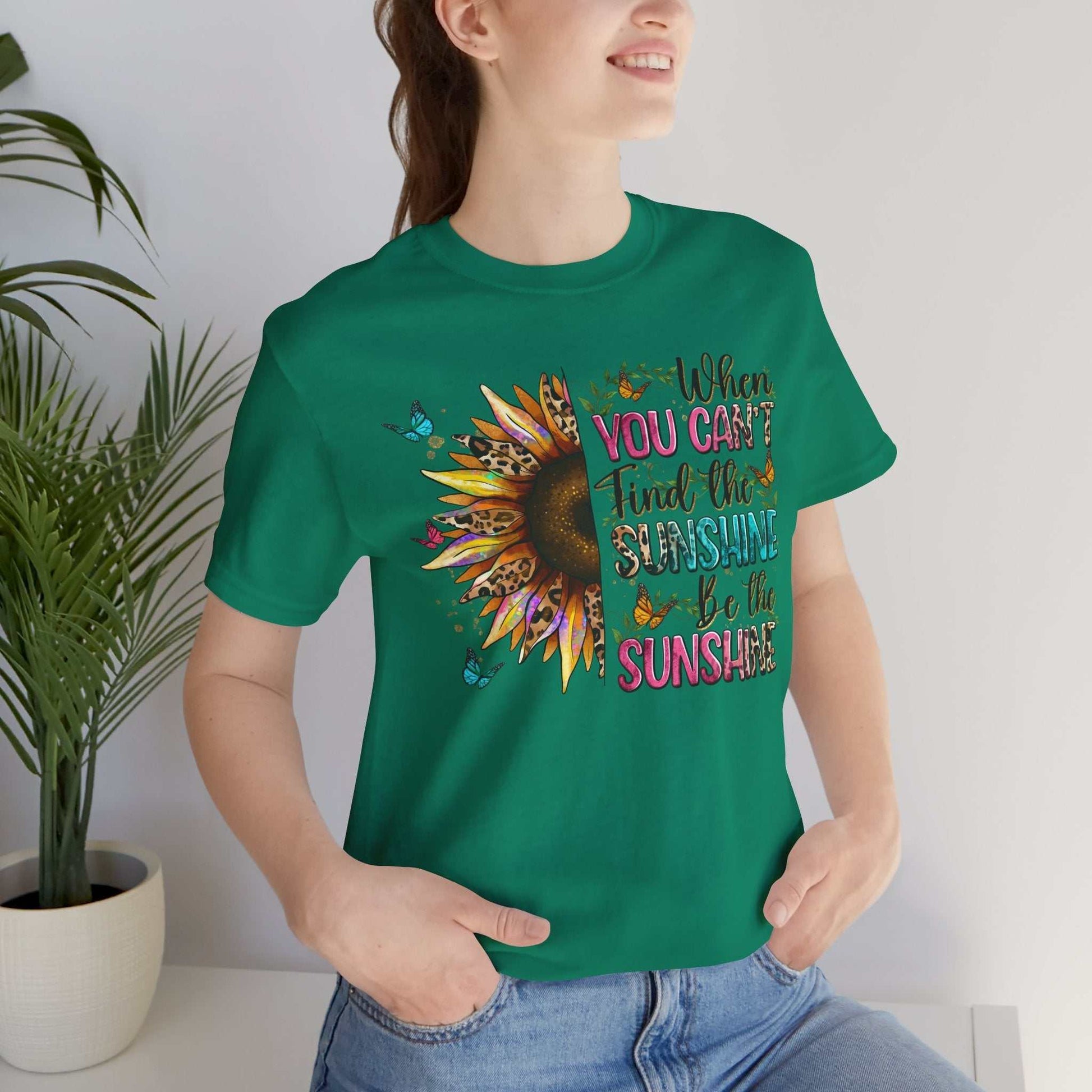 Woman wearing green Sunshine Quote Tee with colorful sunflower and inspirational text design