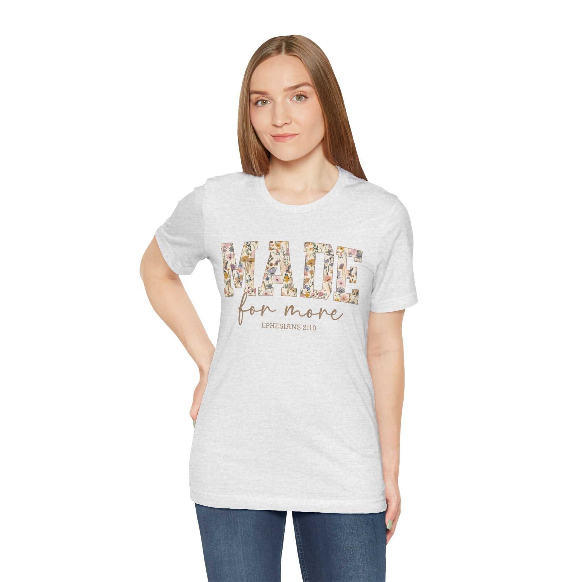 Woman wearing a light gray "Made for More" floral text graphic unisex jersey short sleeve tee with relaxed fit and crew neckline.