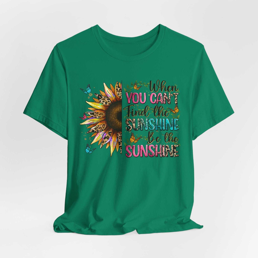 Green unisex t-shirt with half sunflower and colorful "When you can't find the sunshine be the sunshine" quote design.