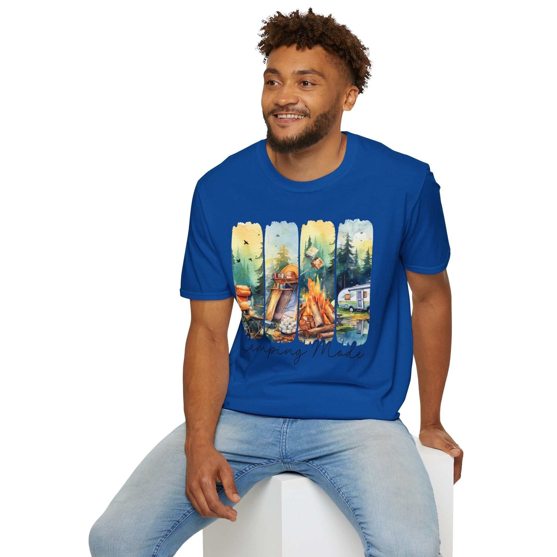 Man wearing blue Camping Adventure Unisex T-Shirt with camping-themed graphic sitting on white block