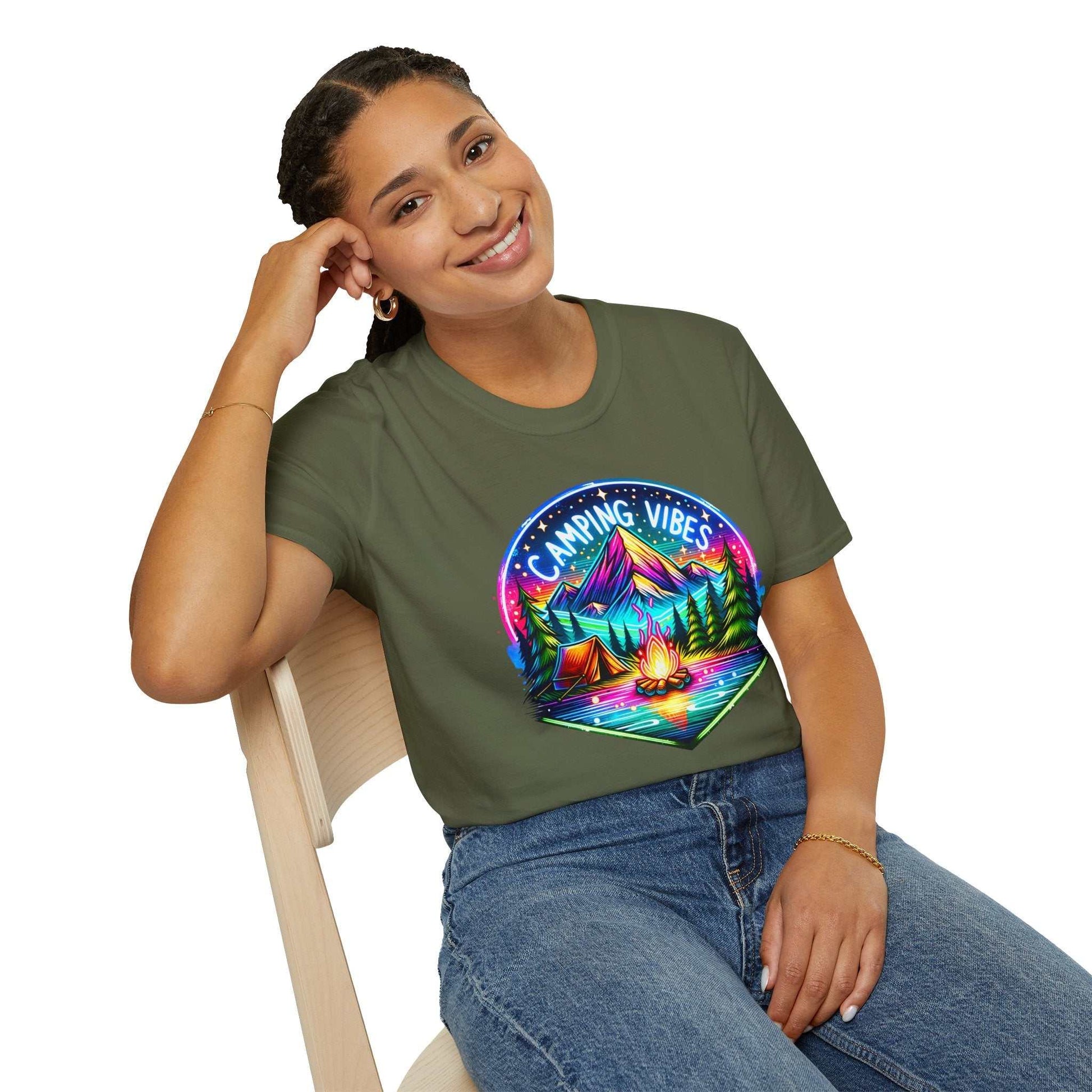 Woman wearing Camping Vibes Unisex Softstyle T-Shirt with colorful camping design sitting on chair