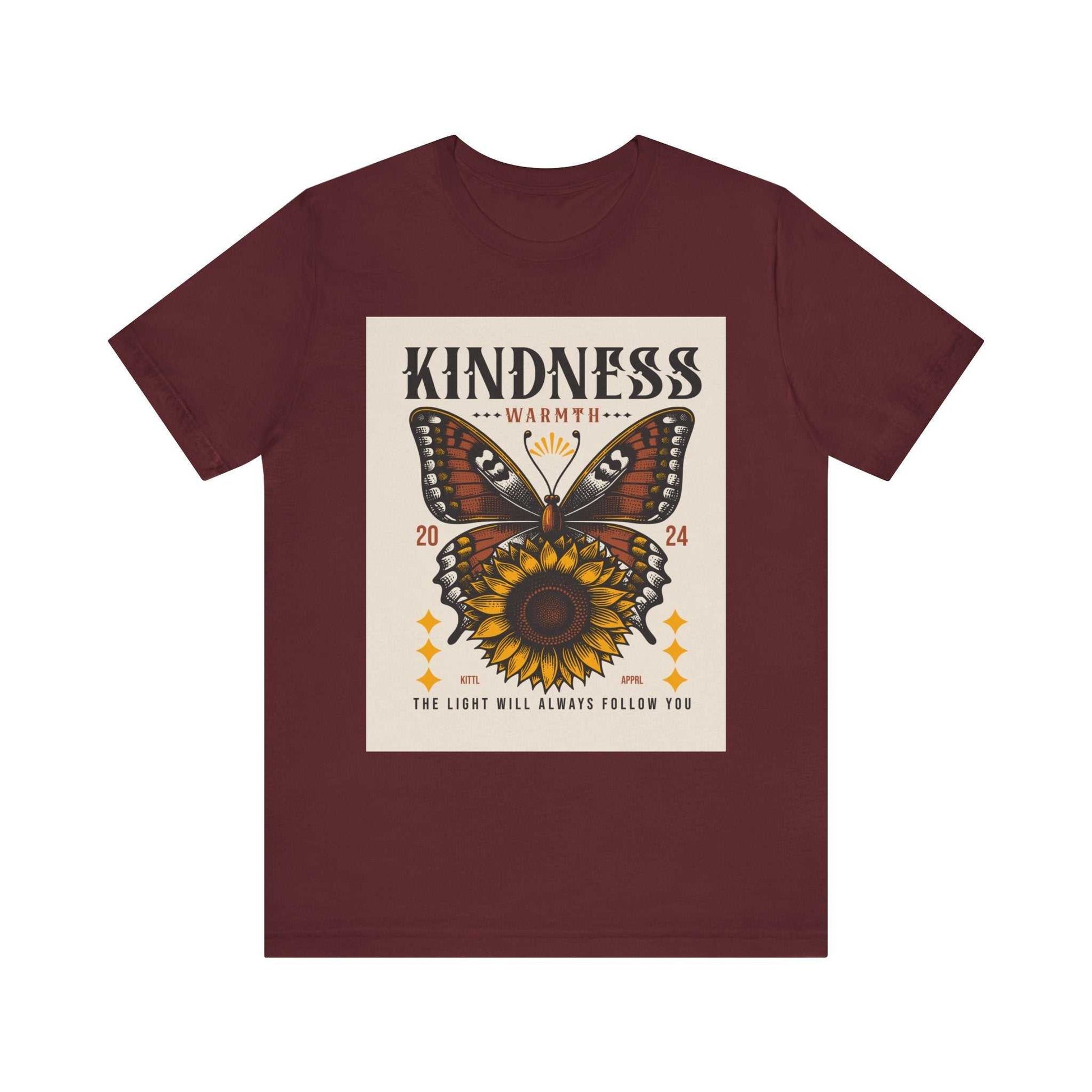 Maroon unisex Kindness Butterfly Tee featuring a butterfly and sunflower graphic with text "Kindness Warmth 2024 The light will always follow you"