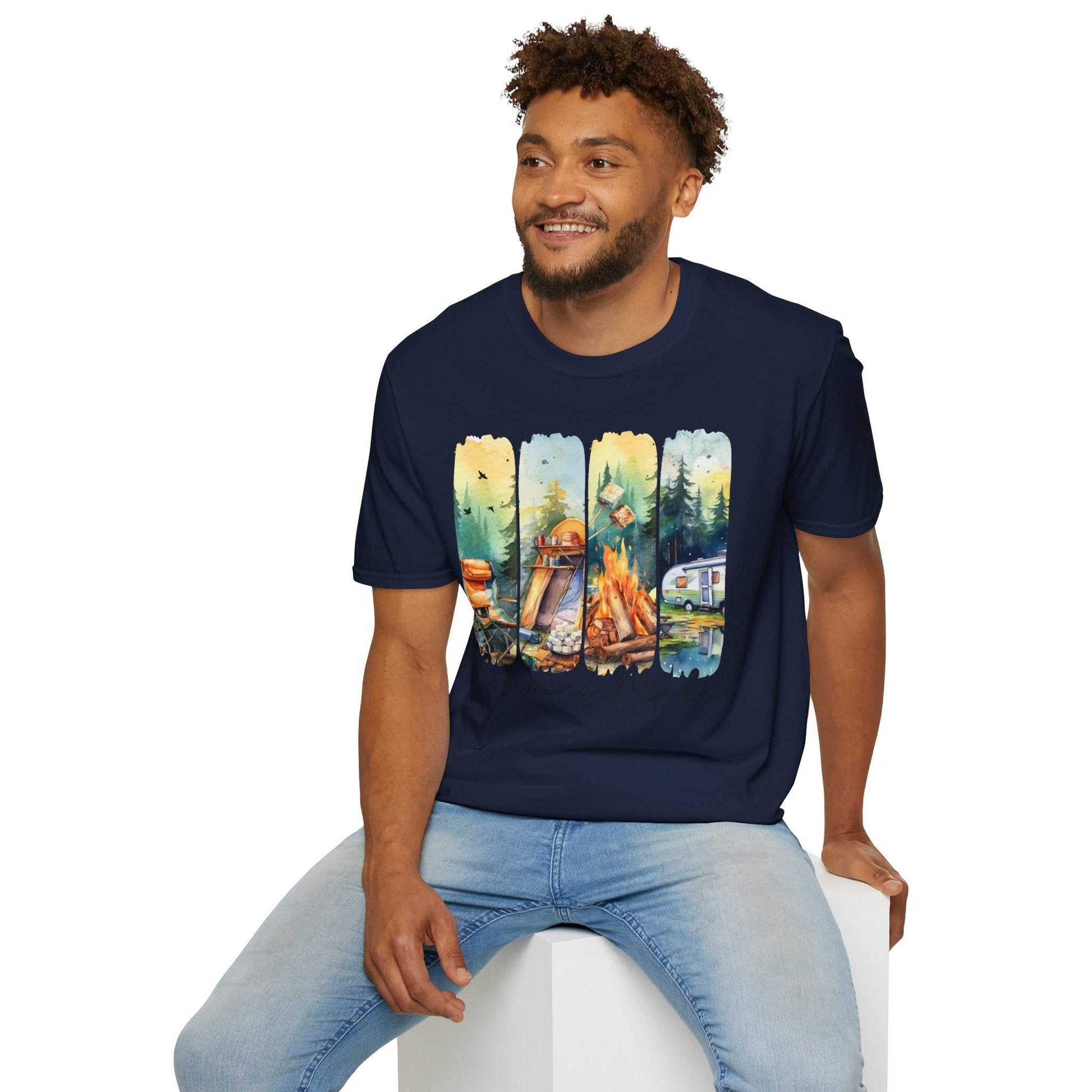 Man wearing navy Camping Adventure Unisex T-Shirt with colorful camping-themed graphic sitting on white block
