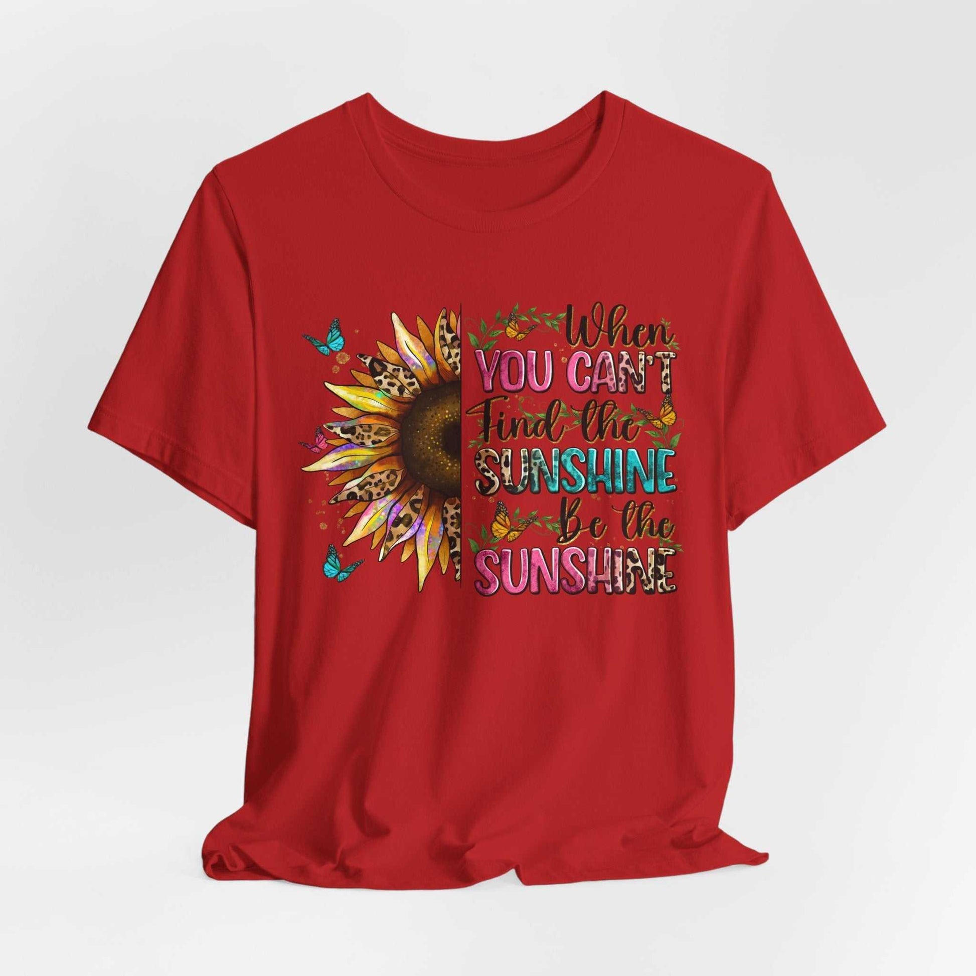 Red unisex short sleeve tee with colorful sunflower and quote "When you can't find the sunshine be the sunshine" design