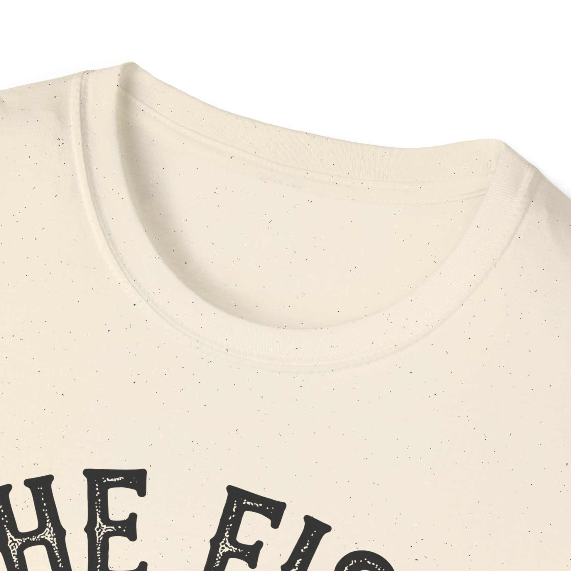 Close-up of cream-colored unisex softstyle t-shirt featuring "The Fish Whisperer" text design