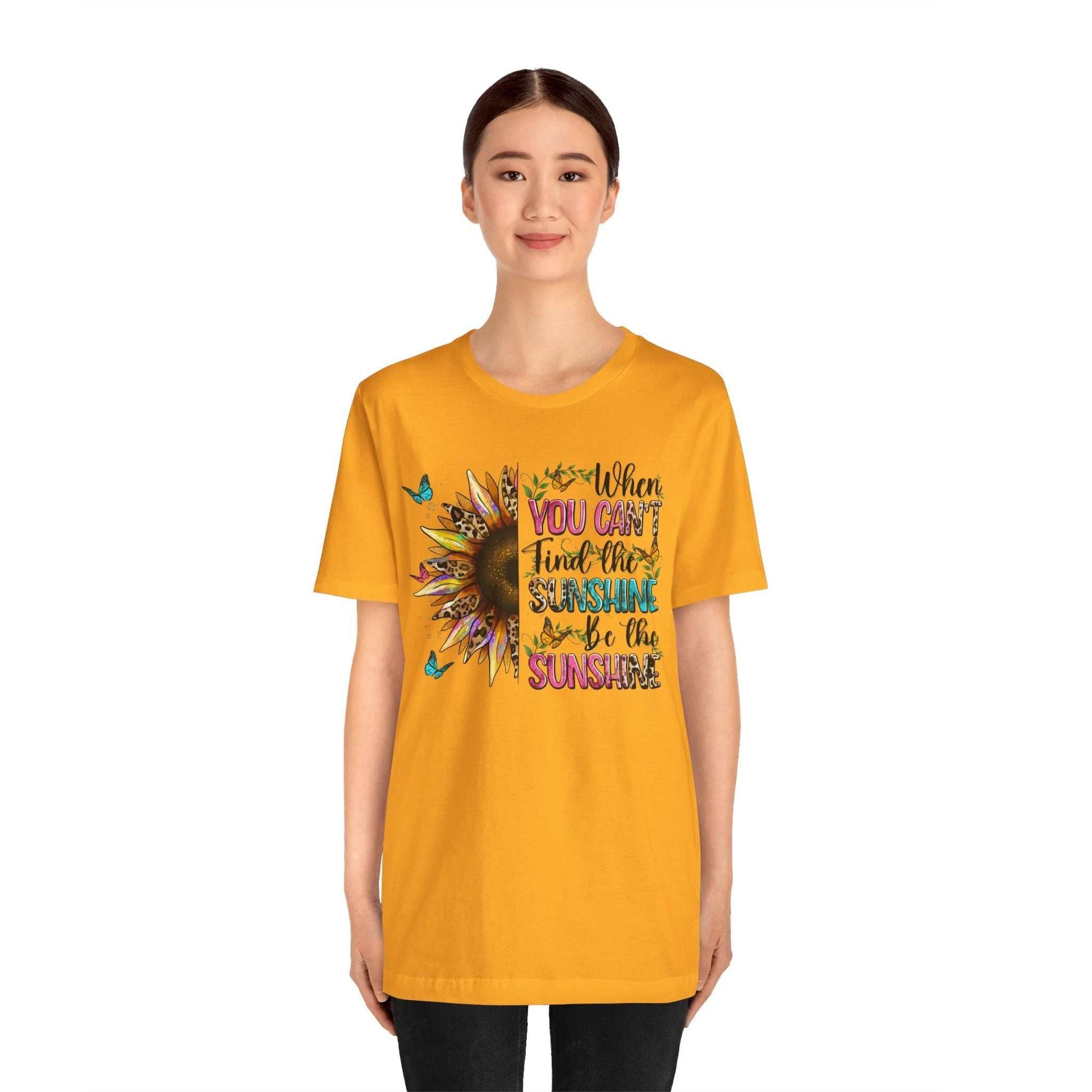 Woman wearing yellow Sunshine Quote Tee with colorful sunflower and inspirational text design