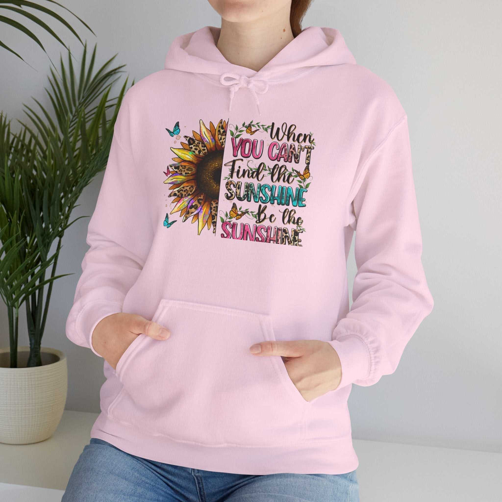 Woman wearing a pink sunflower quote hoodie with colorful inspirational text and butterflies, featuring a kangaroo pocket and adjustable hood.