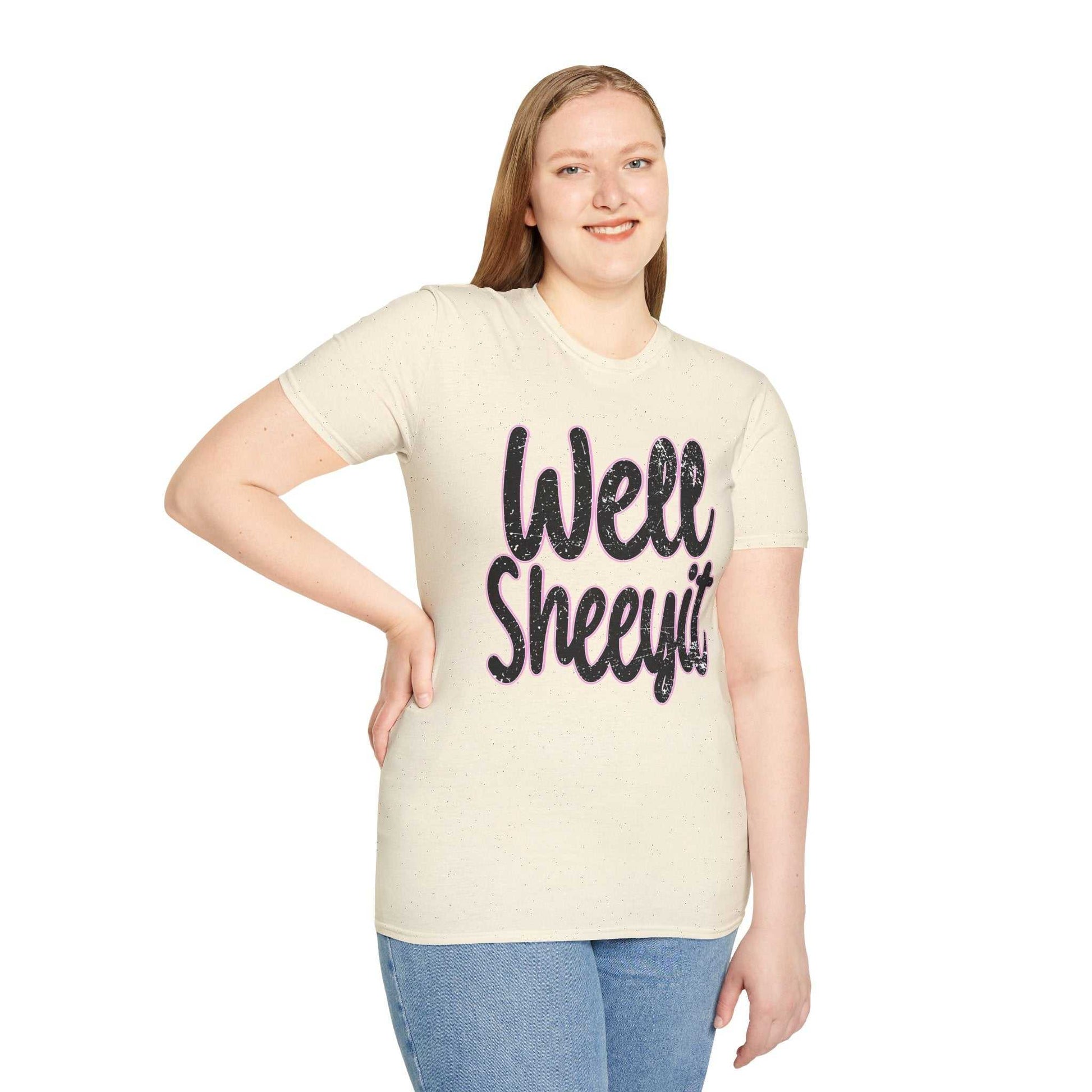 Woman wearing a beige casual statement tee with "Well Sheeyit" funny quote printed on the front, paired with blue jeans.