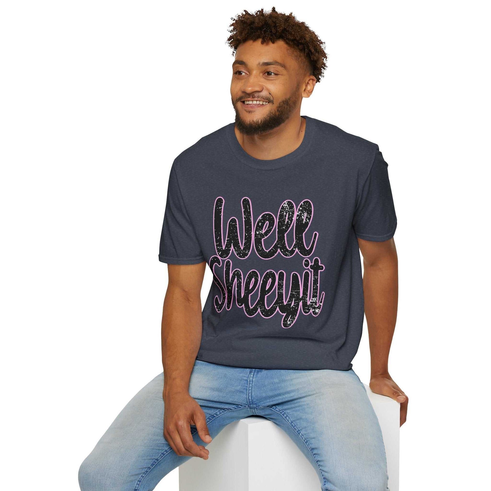 Man wearing navy casual statement tee with "Well Sheeyit" funny quote sitting on white block