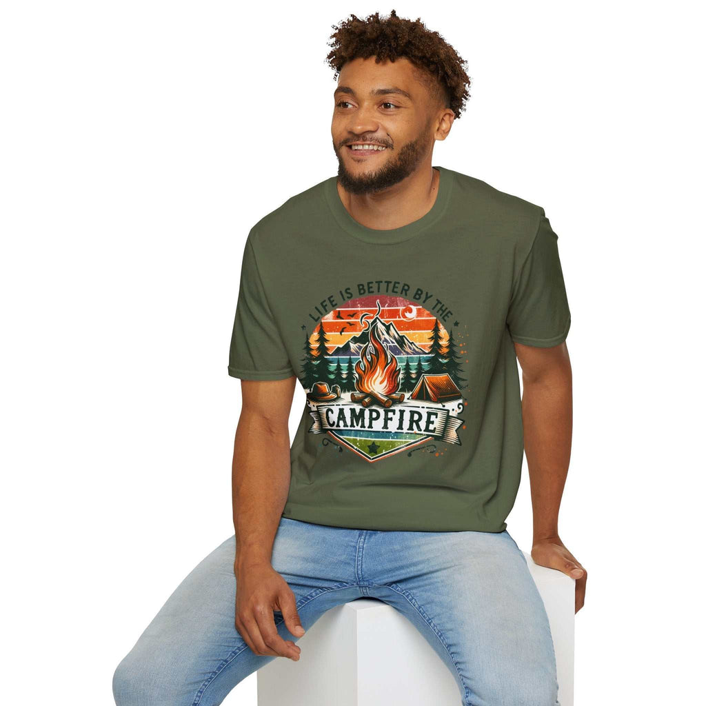 Man wearing olive green Camping Adventure Unisex T-Shirt with "Life is Better by the Campfire" graphic of campfire and trees