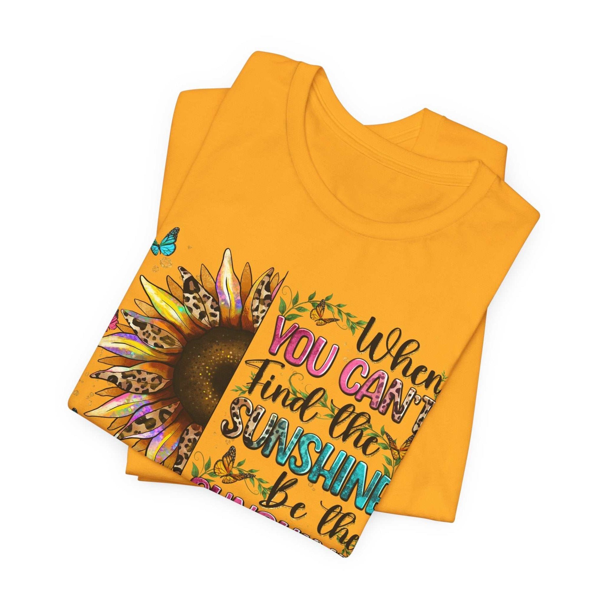 Bright yellow Sunshine Quote Tee with vibrant sunflower and motivational text design folded flat