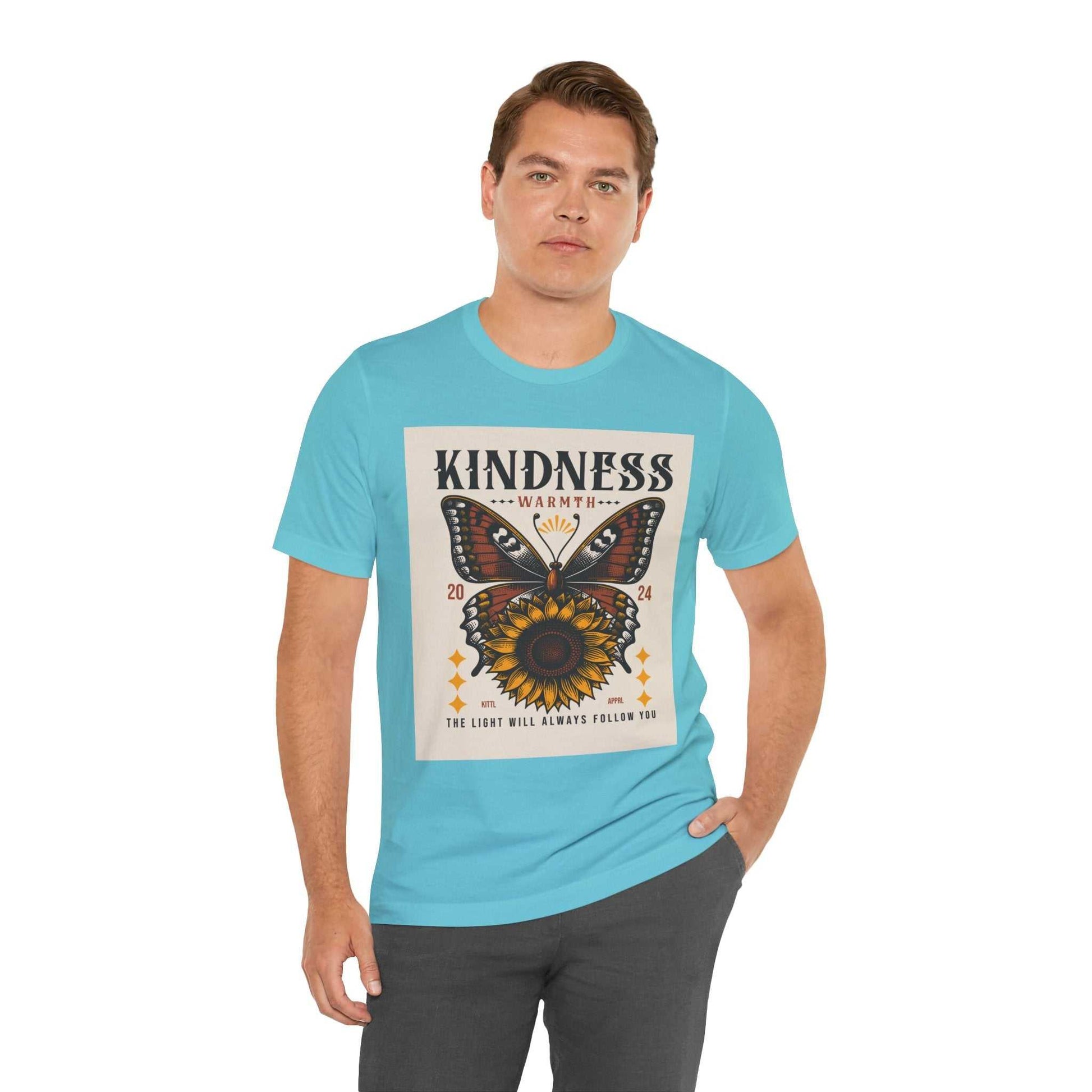 Man wearing a light blue Kindness Butterfly Tee with butterfly and sunflower graphic and text "Kindness Warmth The Light Will Always Follow You"