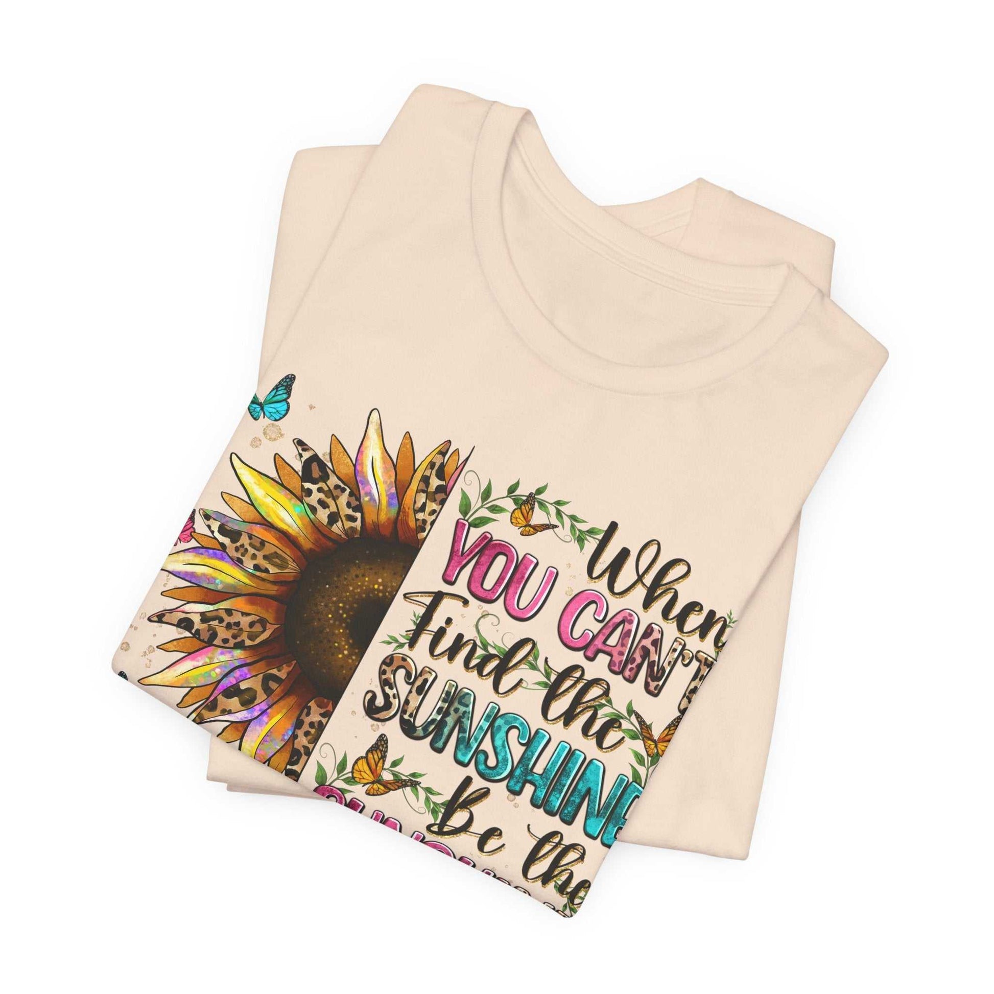 Folded beige Sunshine Quote Tee with colorful sunflower and motivational text design