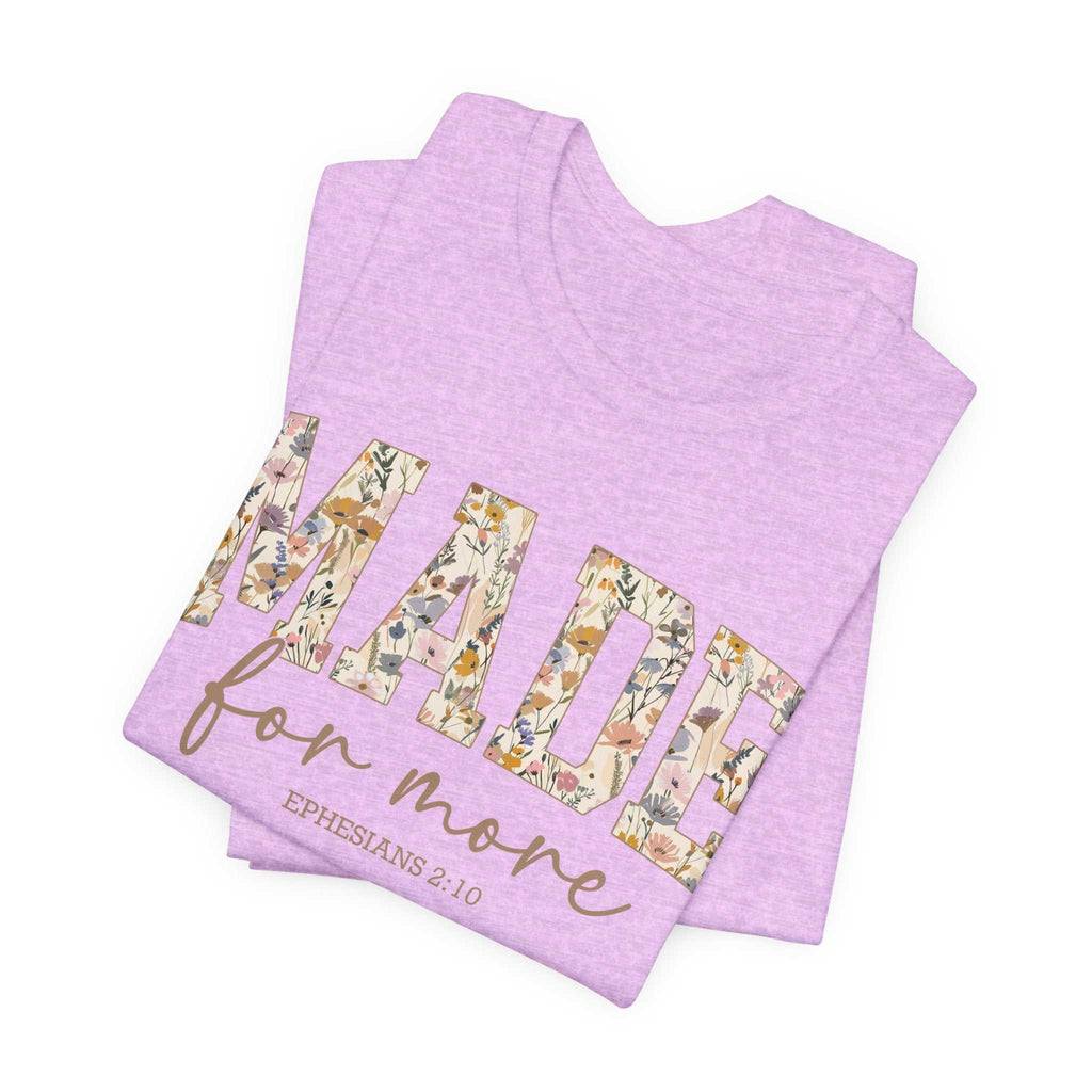 Folded lavender Made for More Tee with floral patterned text and scripture reference Ephesians 2:10 on front