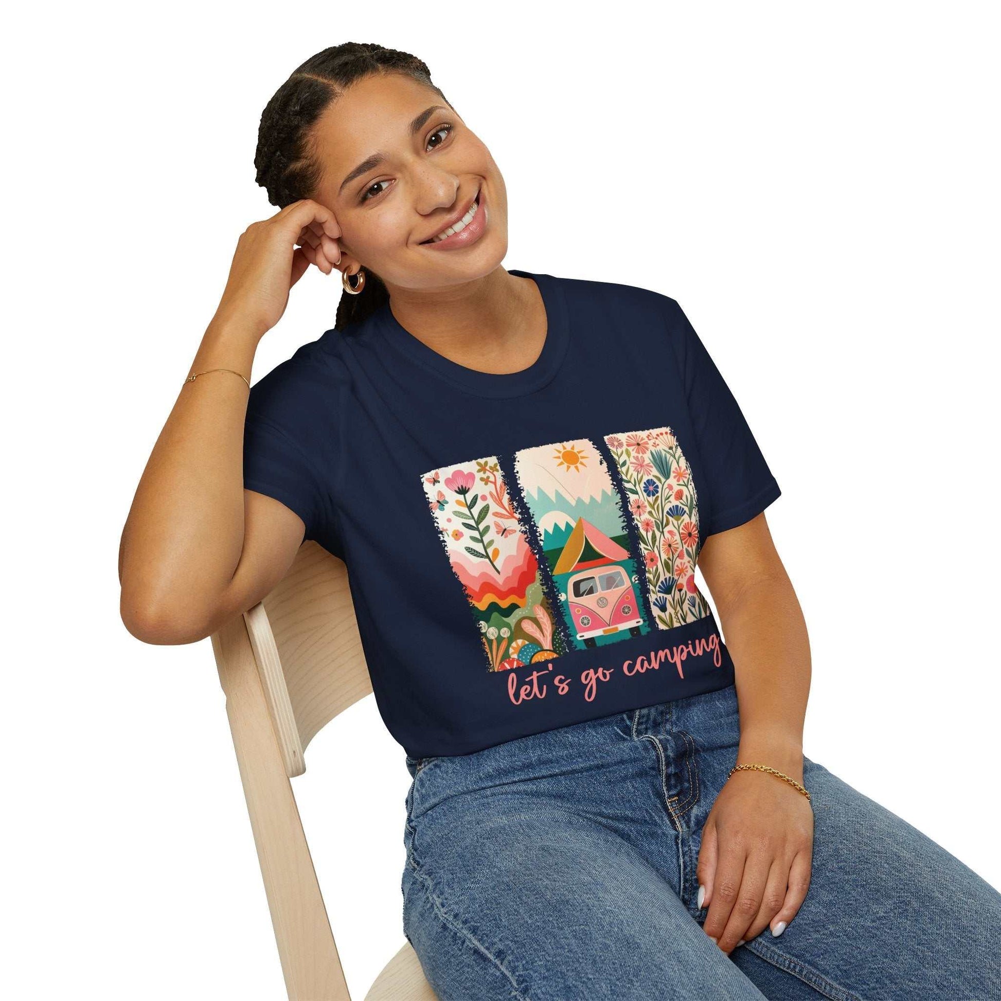 Unisex navy softstyle t-shirt with vibrant Camping Adventure design featuring nature and camper van, modeled sitting and smiling