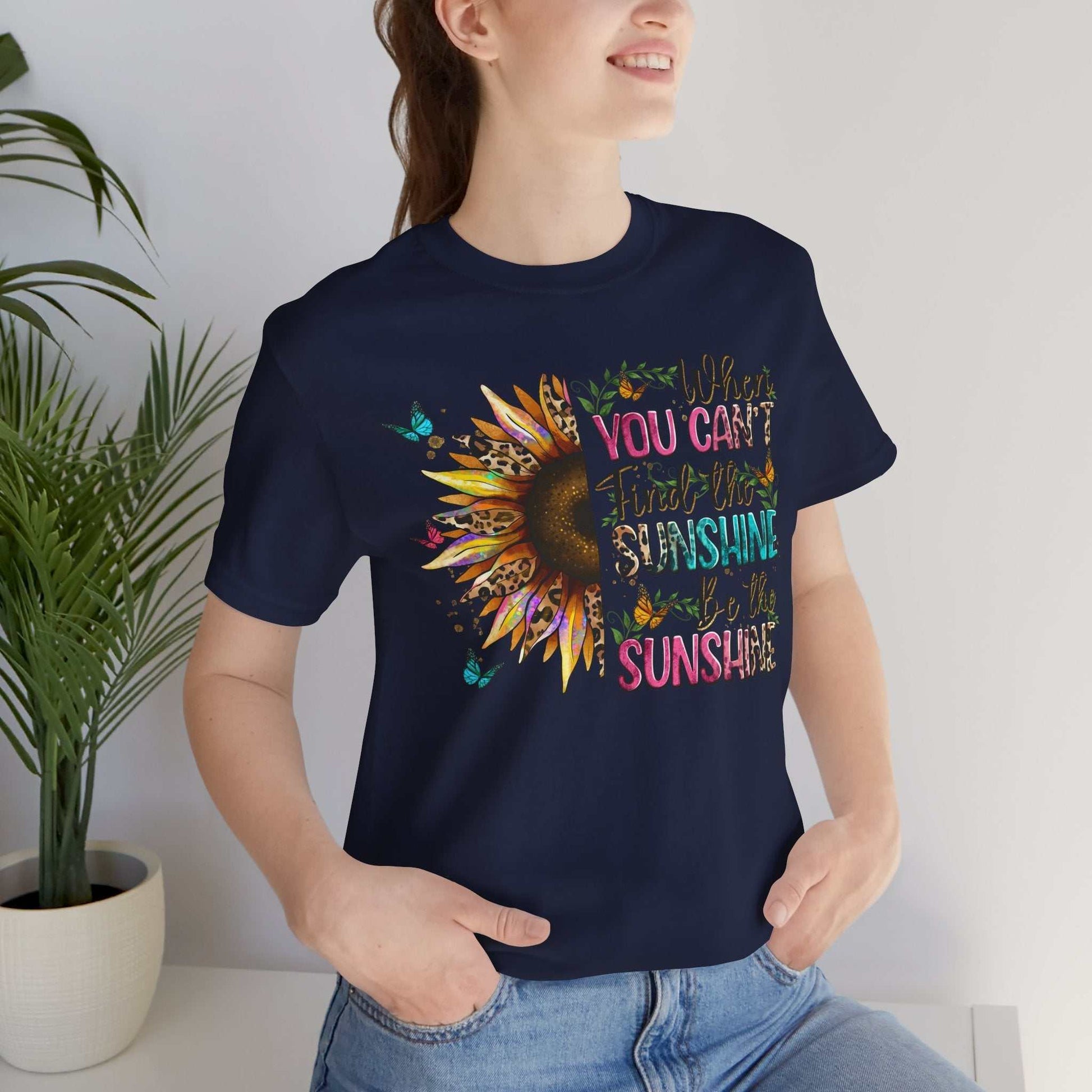 Woman wearing navy Sunshine Quote Tee with colorful sunflower and inspirational text design