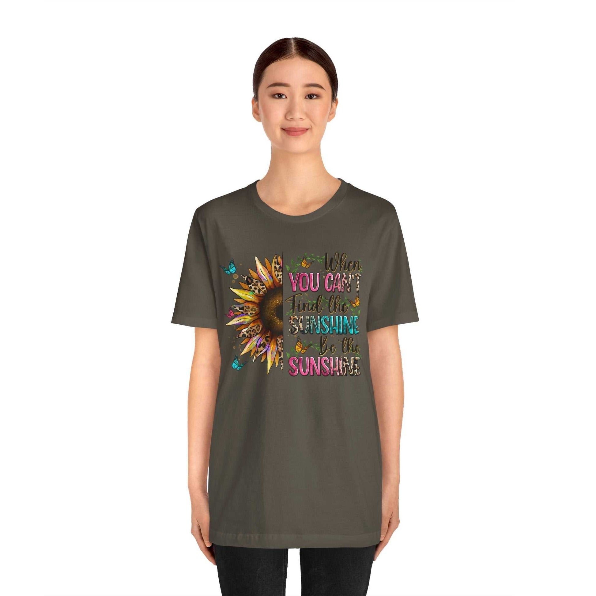 Woman wearing a dark gray Sunshine Quote Tee with colorful sunflower and inspirational text design on the front