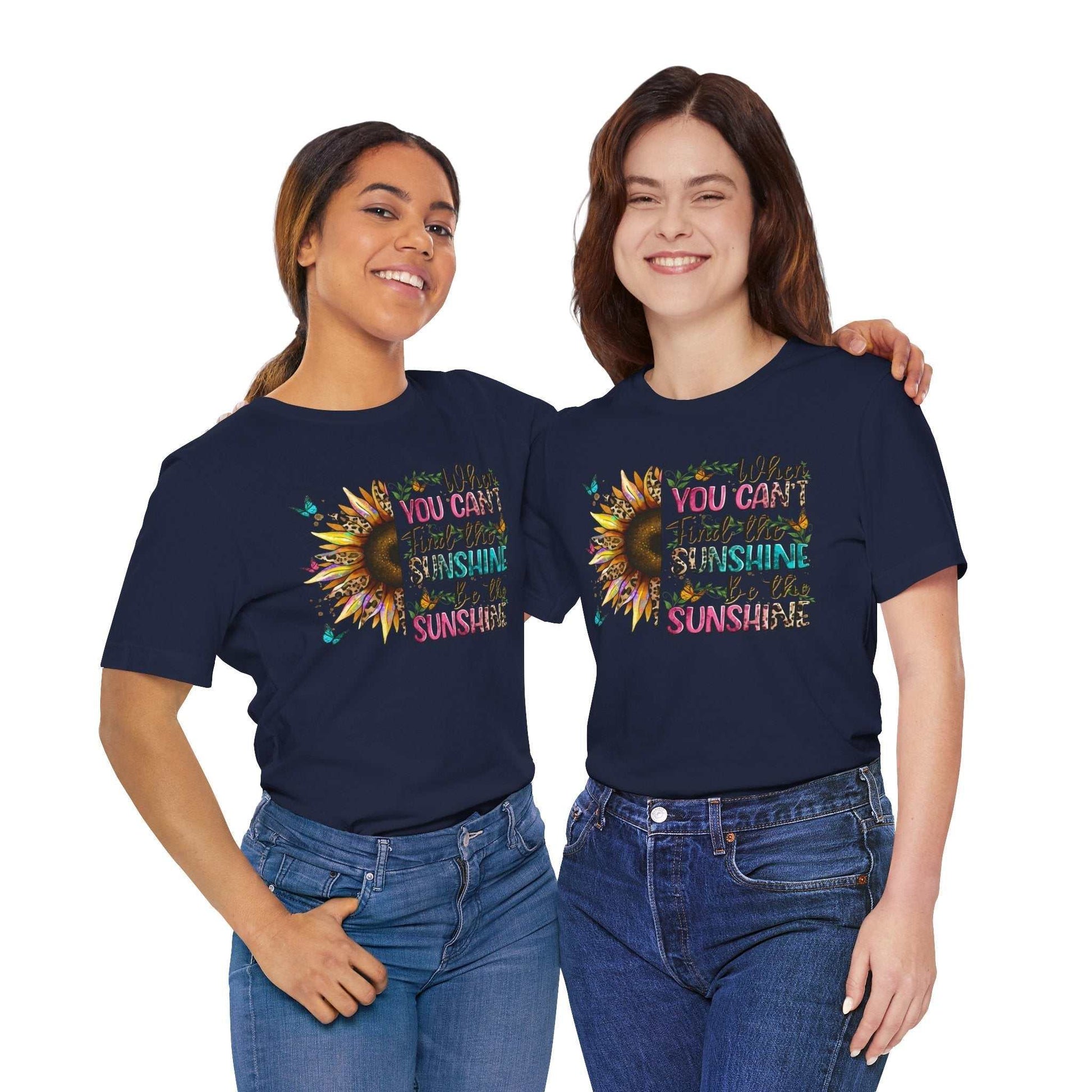 Two women wearing navy blue Sunshine Quote Tee with colorful sunflower and inspirational text design, casual fit and short sleeves