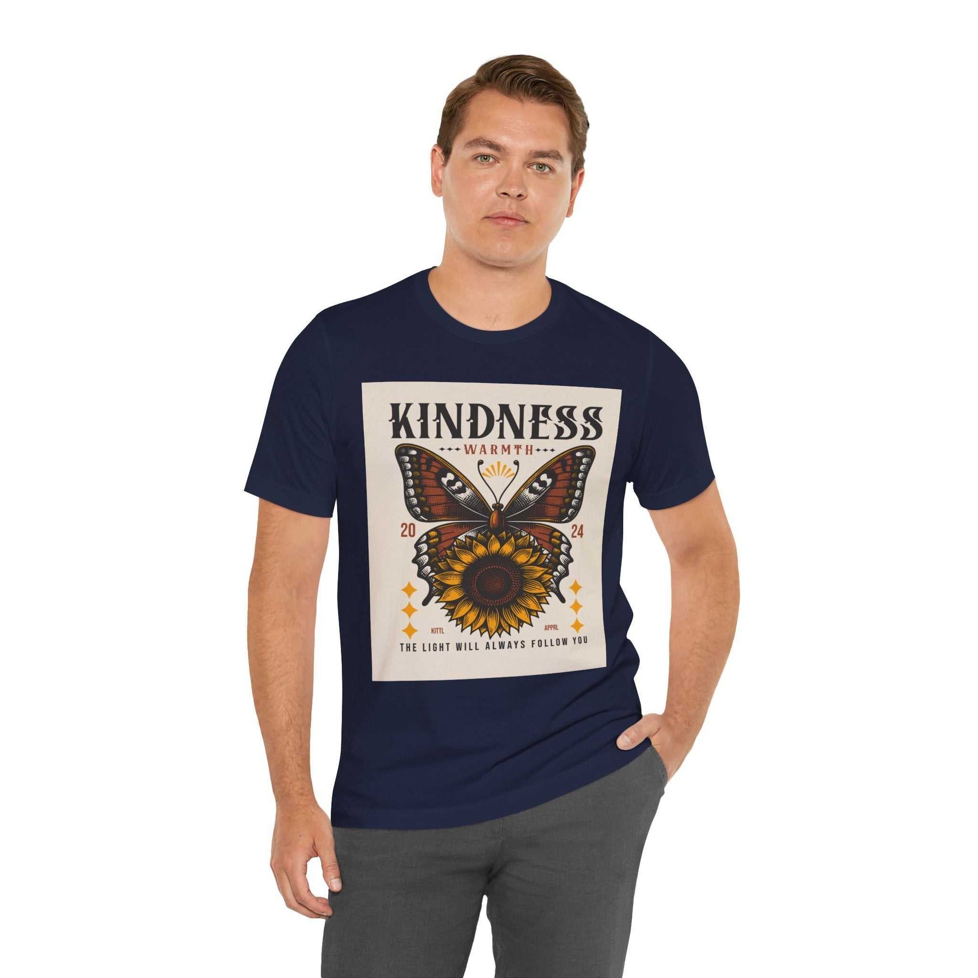Man wearing navy Kindness Butterfly Tee with butterfly and sunflower graphic and positive message on front