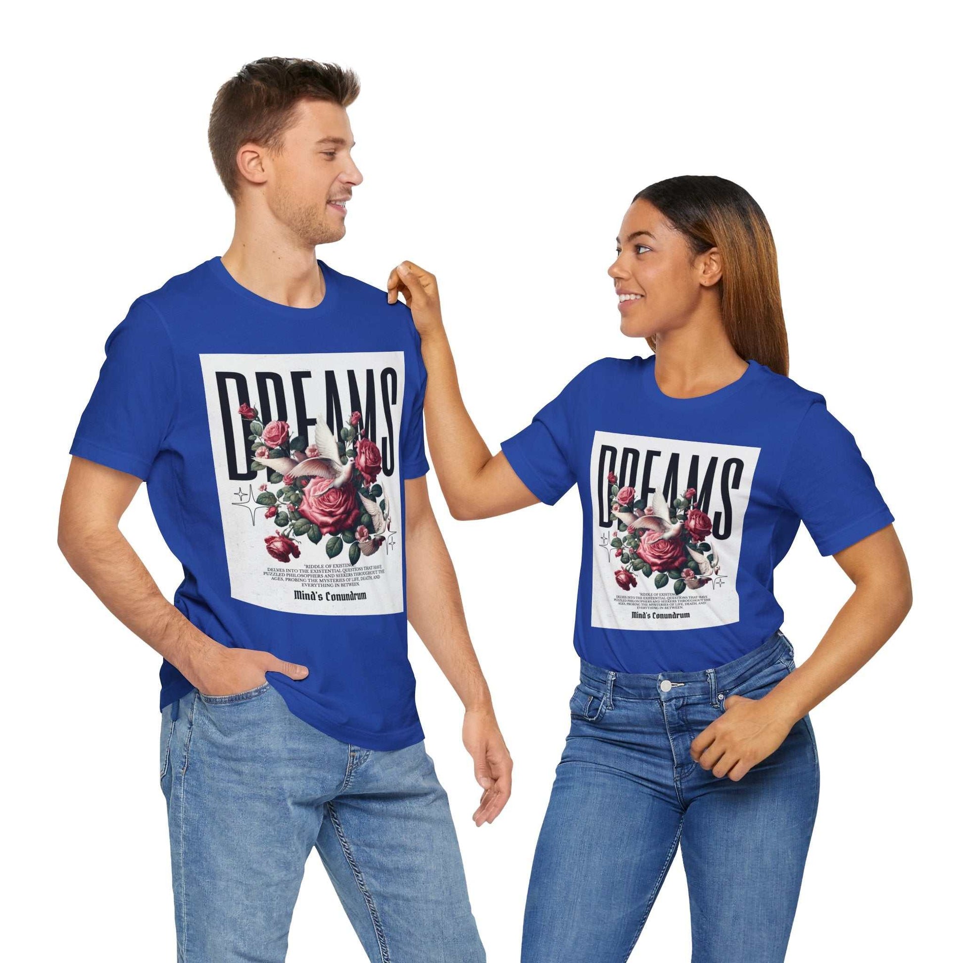 Man and woman wearing blue Dreams Floral Tee with pink flower graphic and bold "DREAMS" text, paired with jeans.