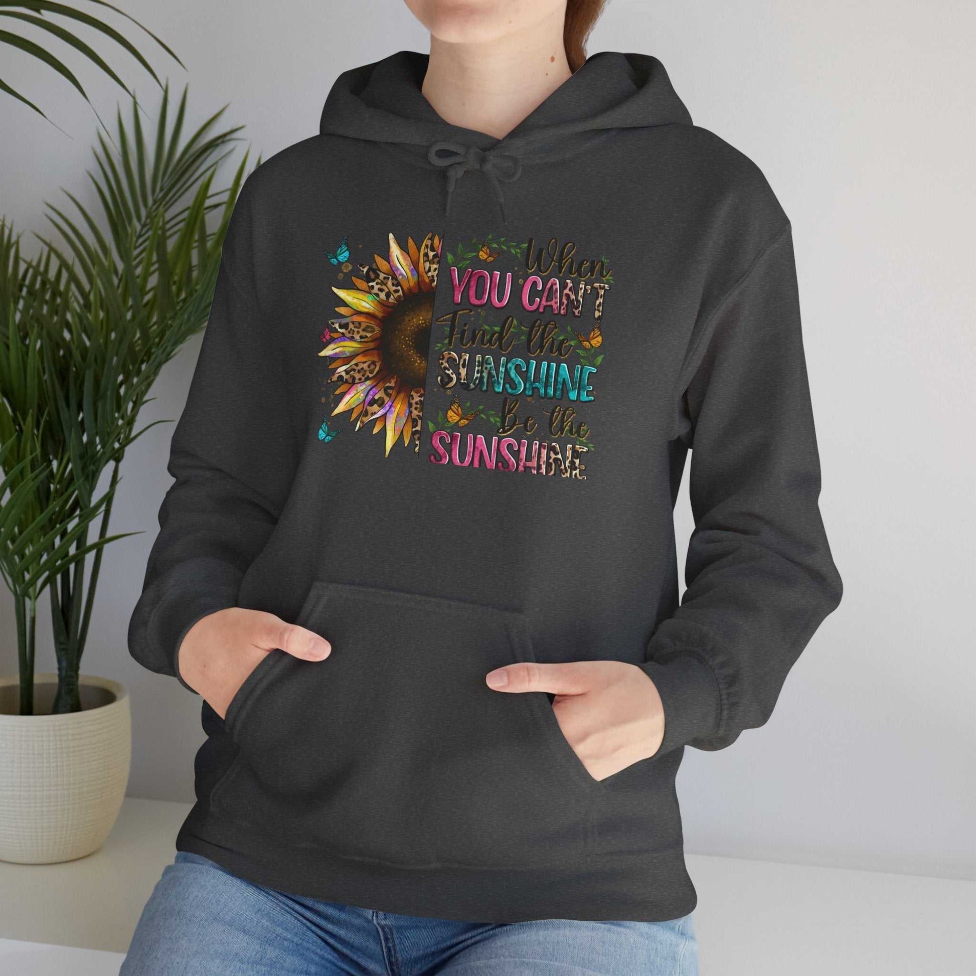 Black sunflower quote hoodie with colorful inspirational text and kangaroo pocket, worn casually