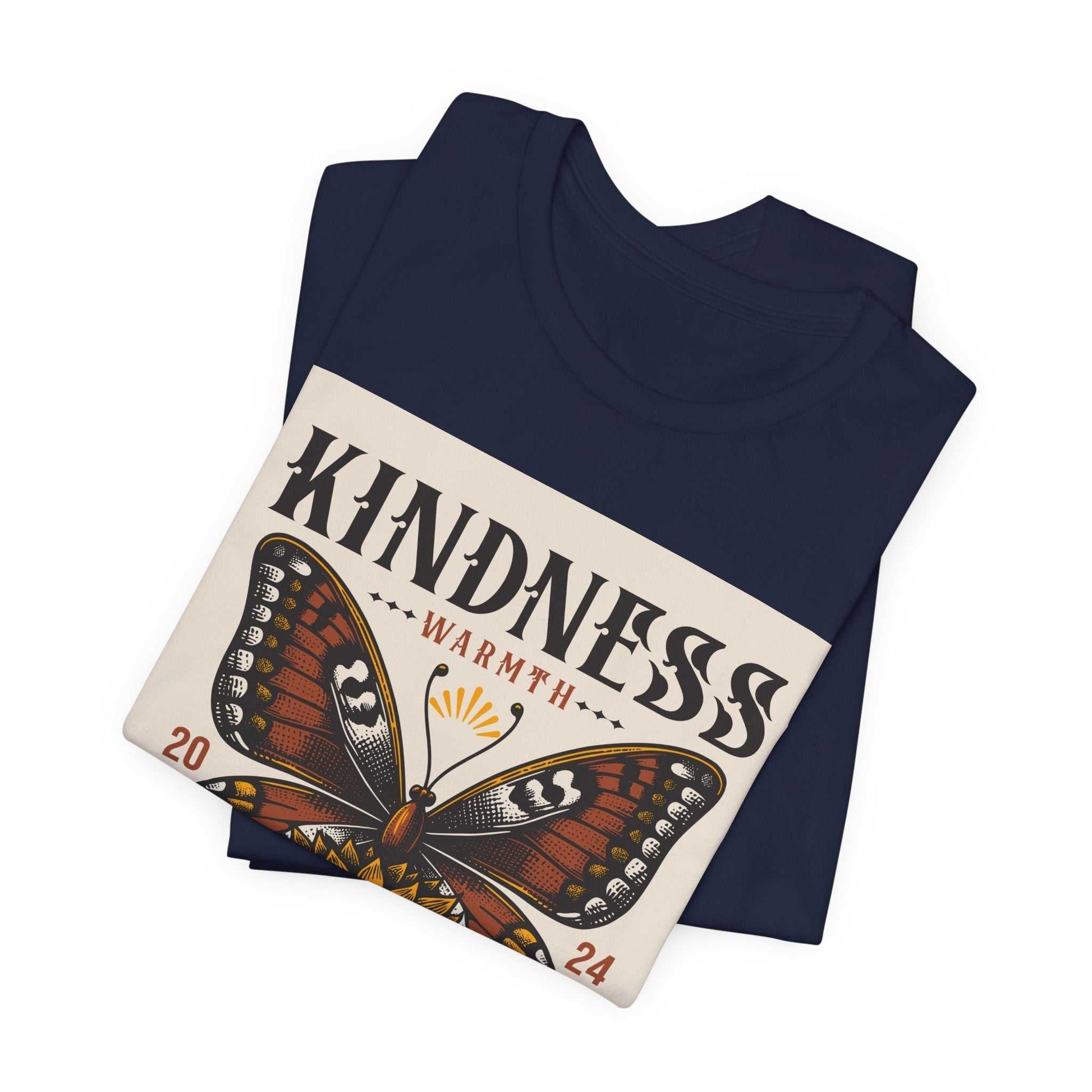 Folded navy blue Kindness Butterfly Tee with a butterfly and sunflower graphic and the word "KINDNESS" printed on the front