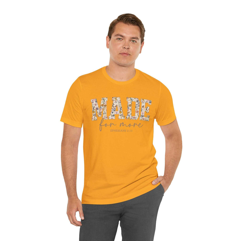 Man wearing orange Made for More Tee with floral text design on front