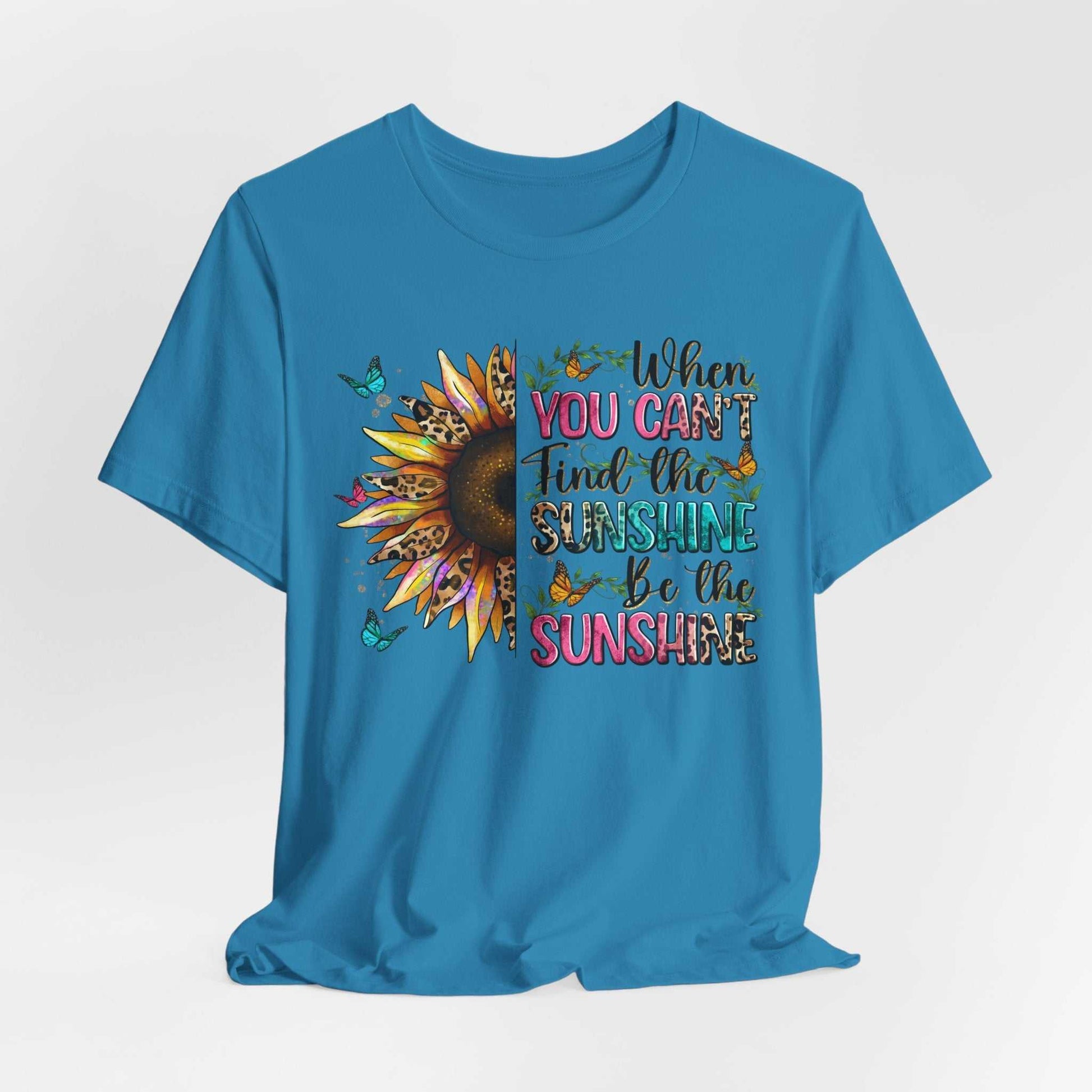 Blue Sunshine Quote Tee with sunflower and butterflies graphic, featuring the motivational text "When you can't find the sunshine be the sunshine"