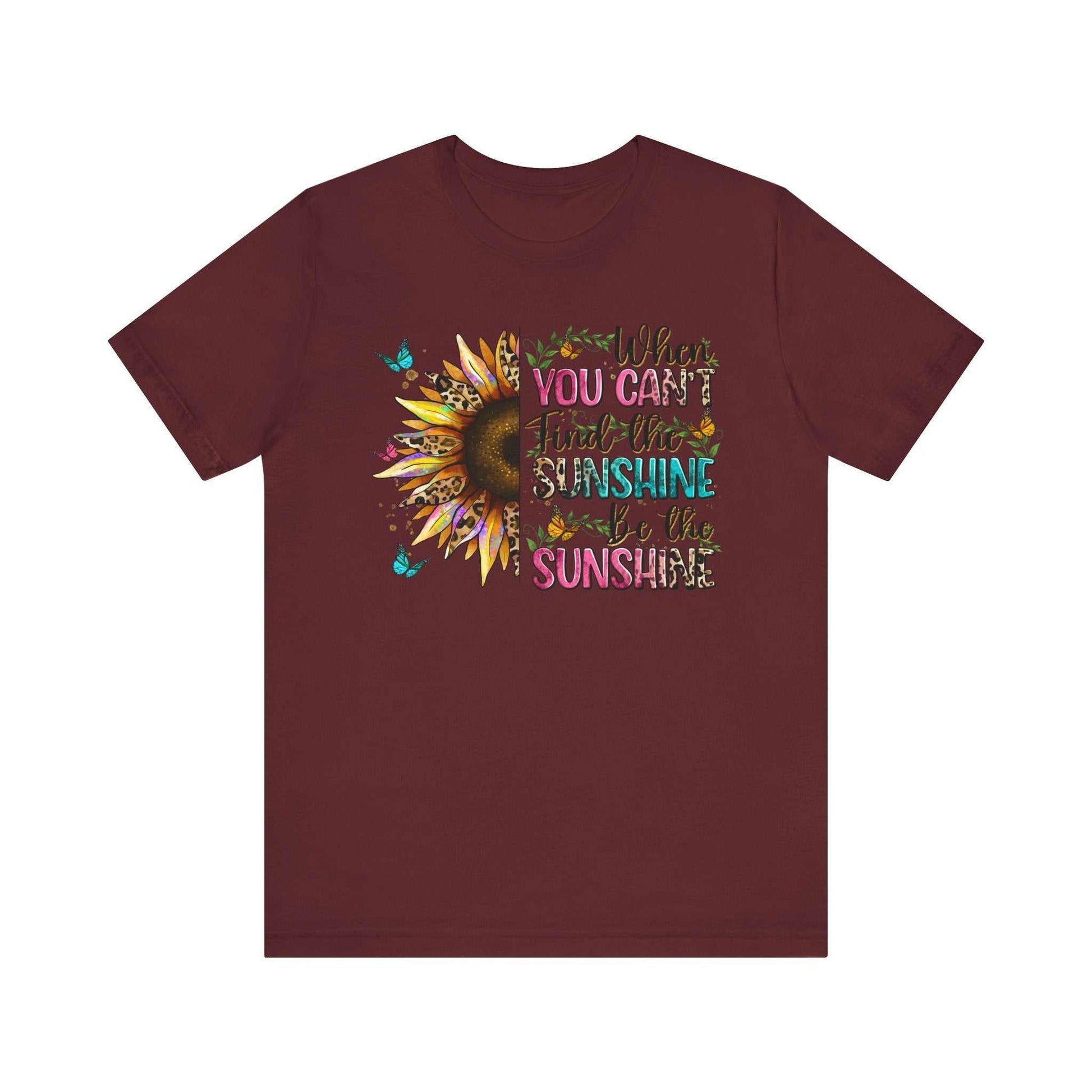 Maroon short sleeve t-shirt with colorful sunflower and quote design saying "When you can't find the sunshine be the sunshine"