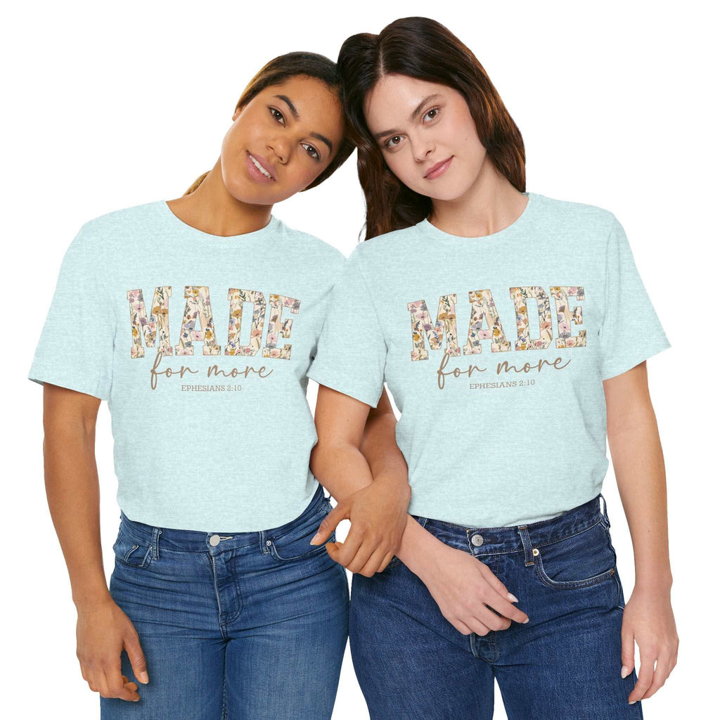 Two women wearing light blue "Made for More" unisex jersey short sleeve tees with floral design and scripture text, styled casually with jeans.