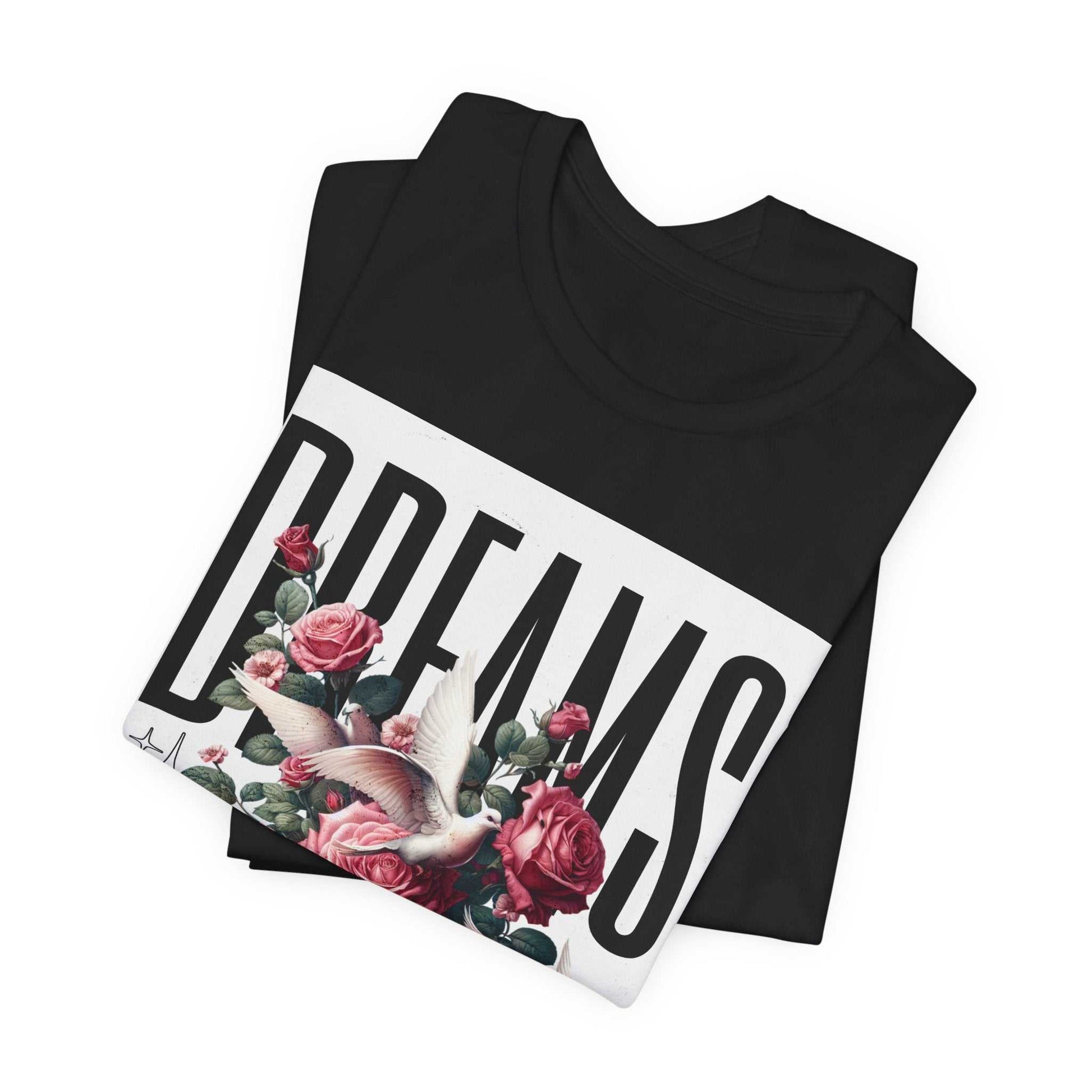 Black Dreams Floral Tee featuring bold white text and pink rose and dove graphic design, folded display