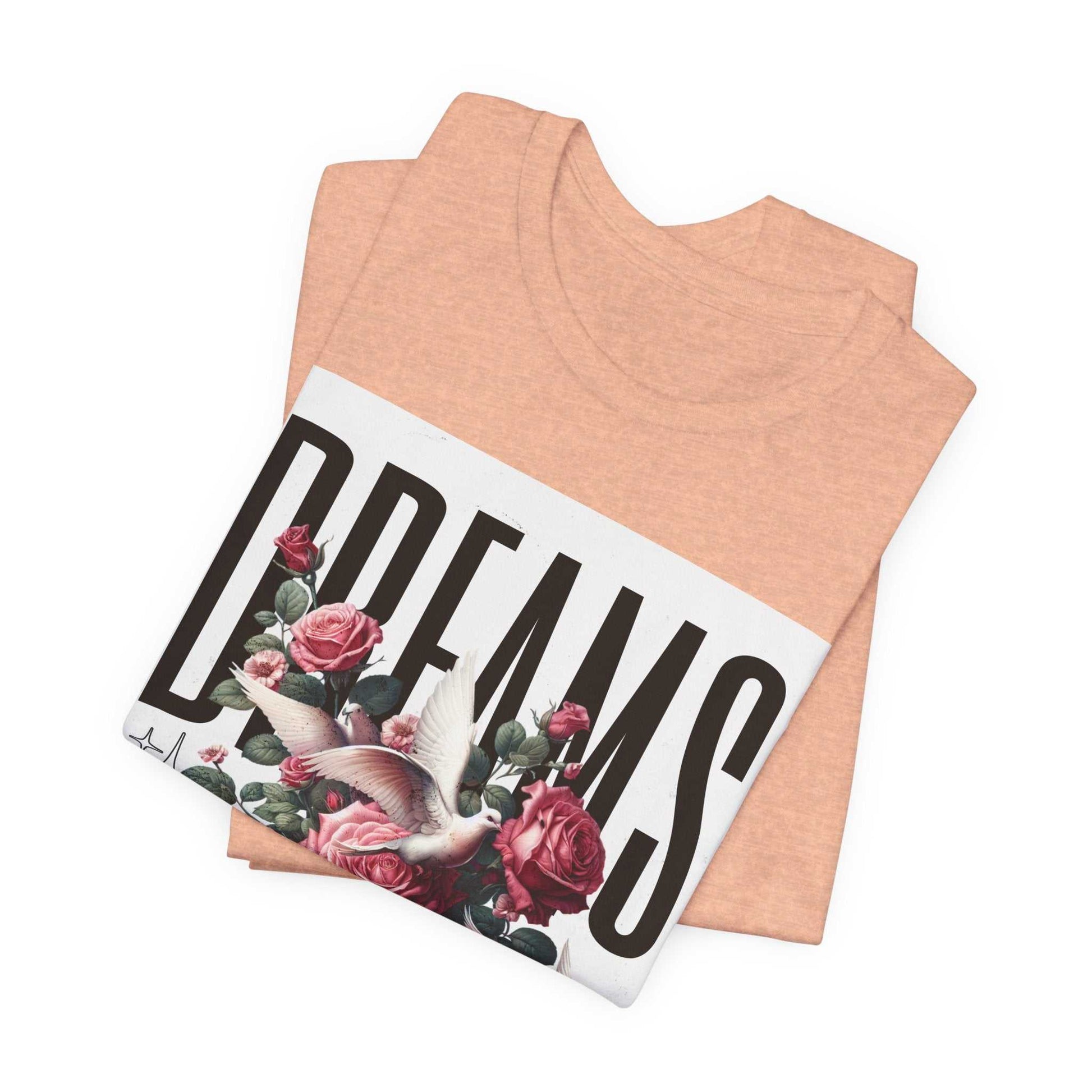 Folded peach Dreams Floral Tee with bird and rose print and bold typography design