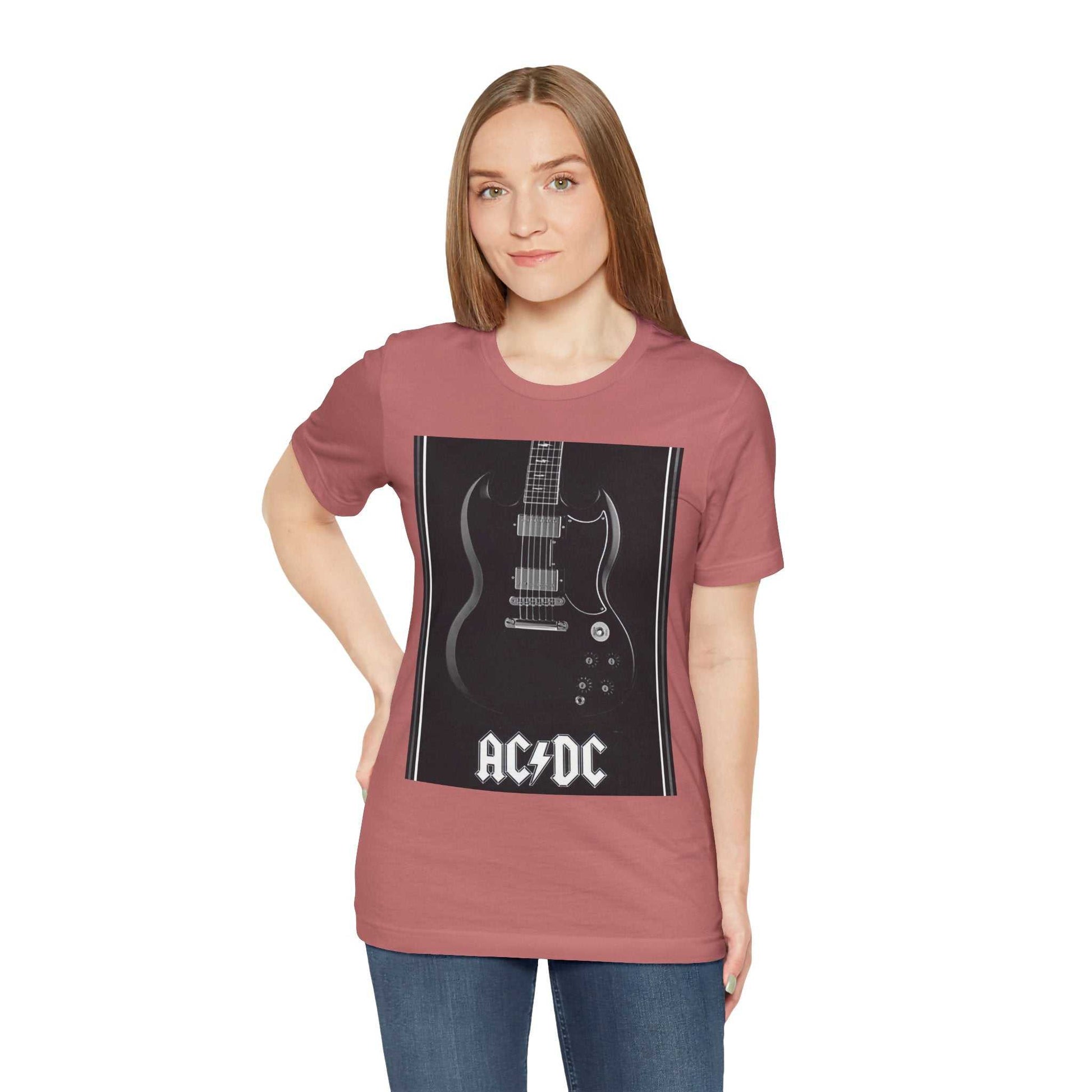 Woman wearing a dusty rose Rock Guitar Graphic Tee featuring a black electric guitar and AC/DC logo on the front