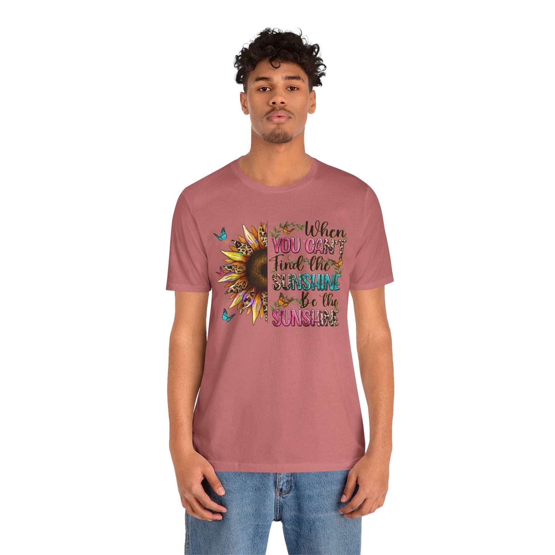 Man wearing a dusty rose Sunshine Quote Tee with a colorful sunflower and uplifting quote design on the front.