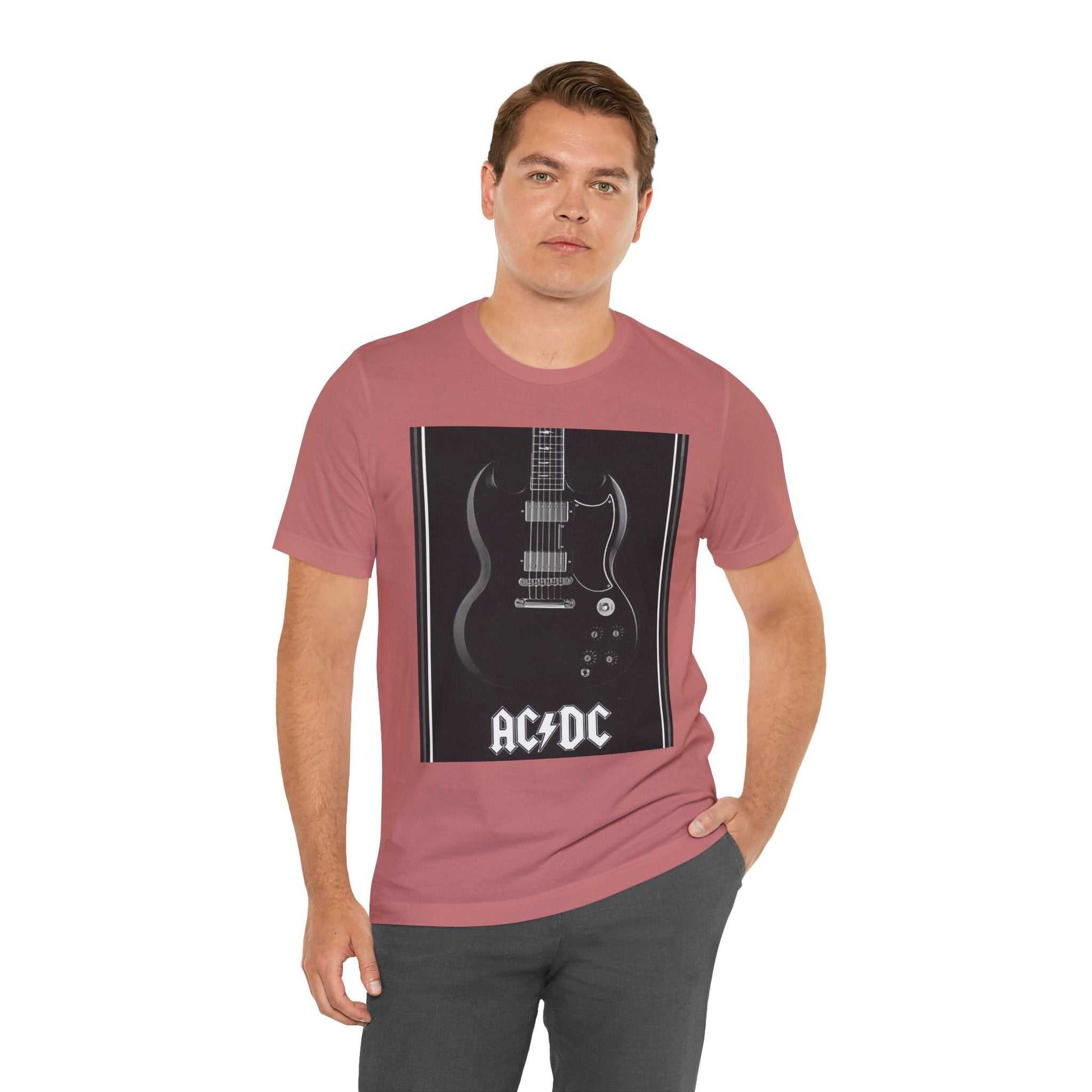Man wearing a pink rock guitar graphic tee featuring a black electric guitar and AC/DC logo.