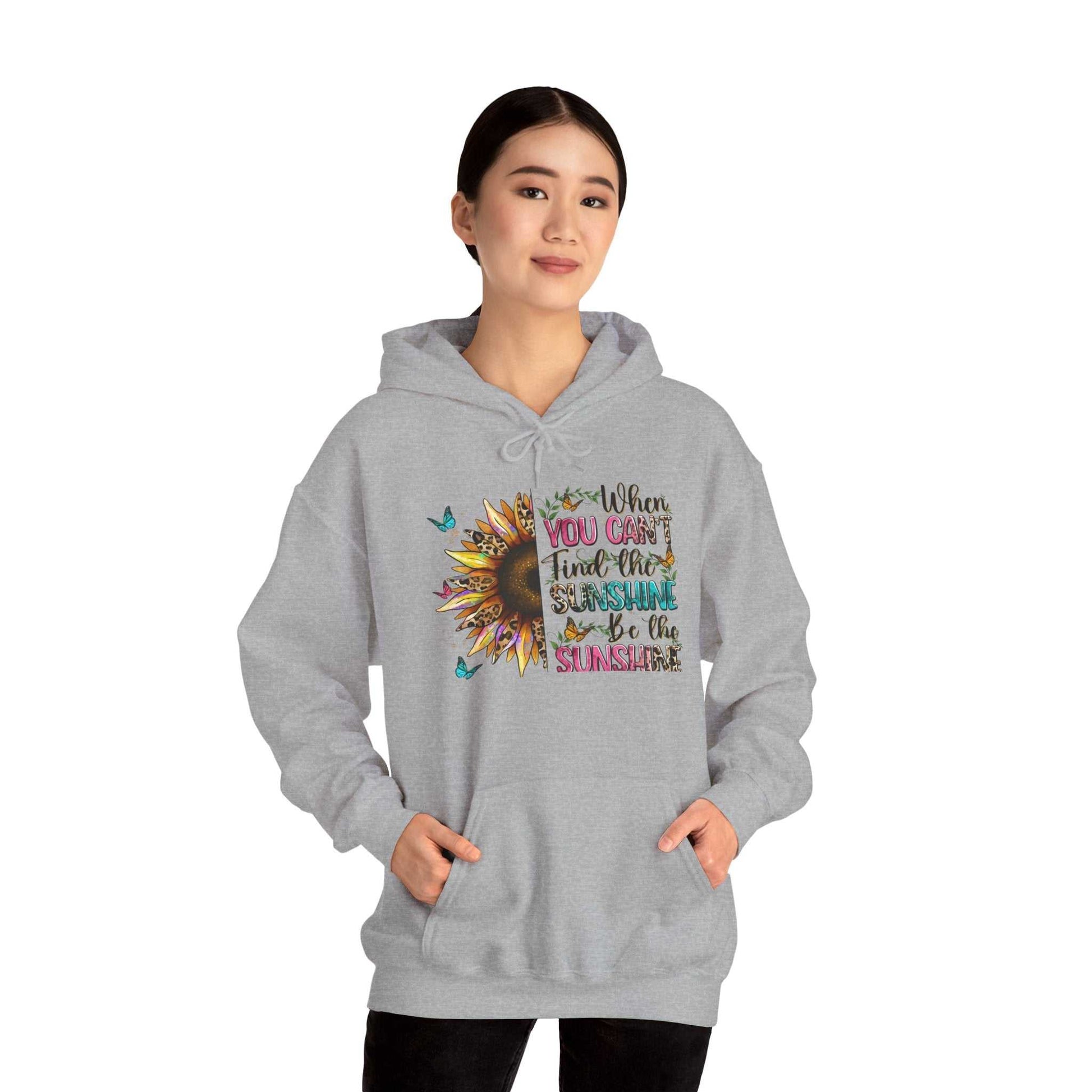 Woman wearing gray sunflower quote hoodie with inspirational sunshine message and kangaroo pocket