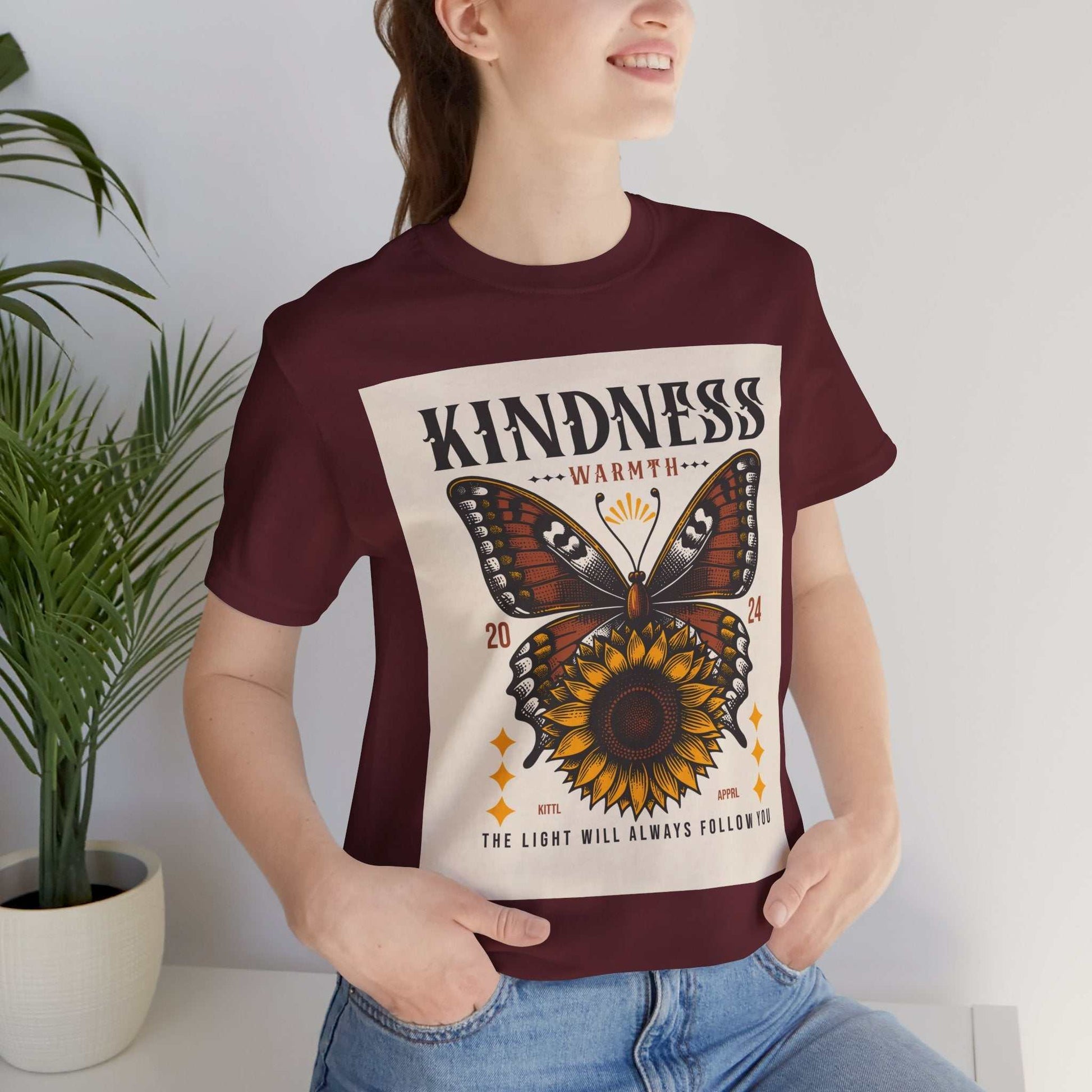 Woman wearing maroon Kindness Butterfly Tee with butterfly and sunflower design and positive message