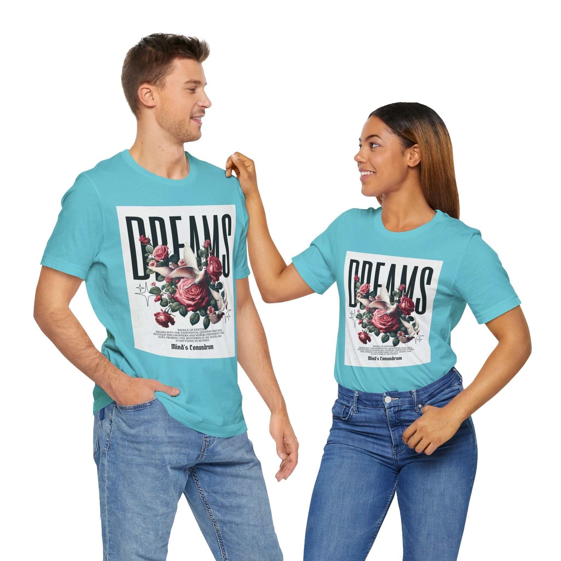 Unisex turquoise Dreams Floral Tee with bold floral print and typography, modeled by man and woman in casual jeans