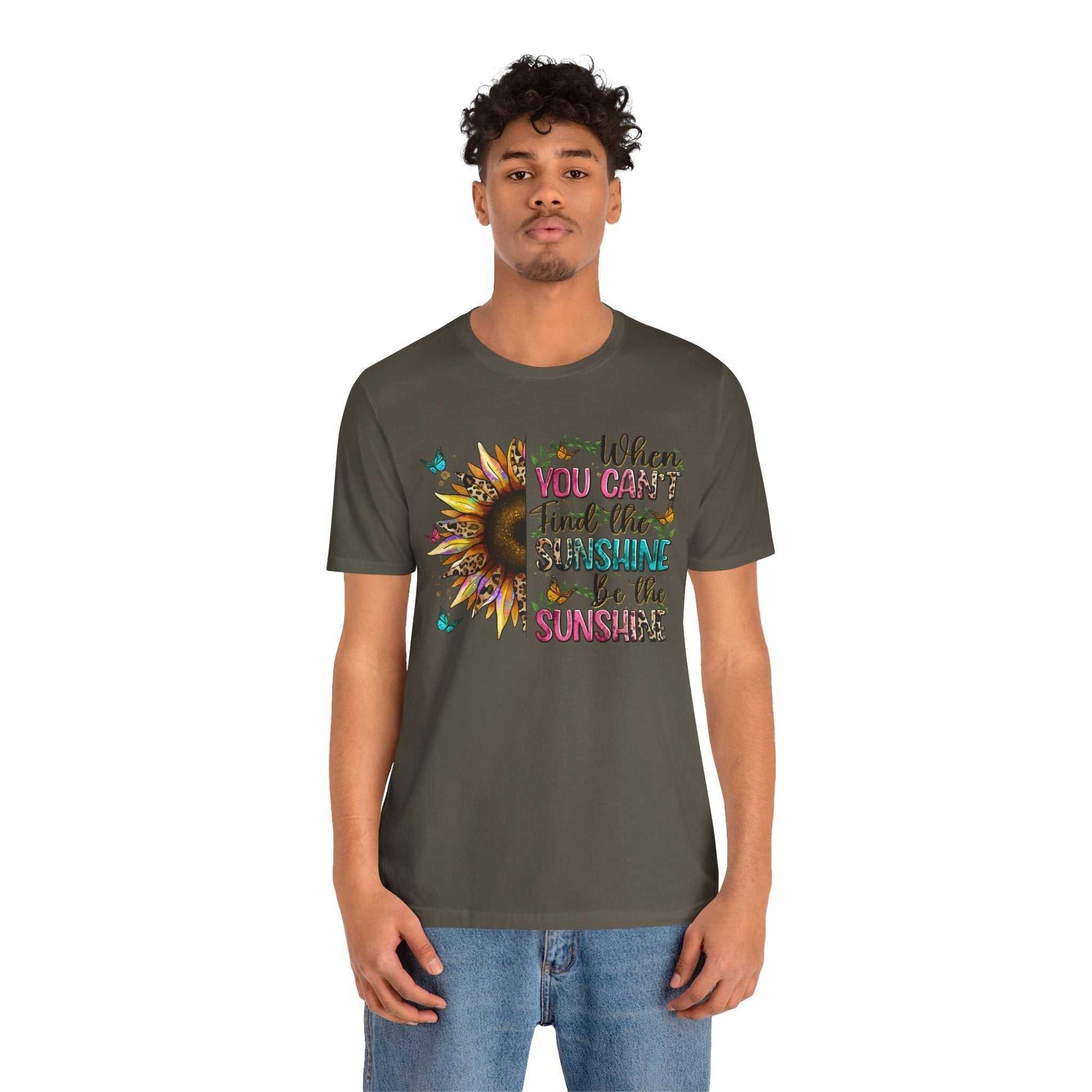 Young man wearing olive green Sunshine Quote Tee with vibrant sunflower and motivational text design