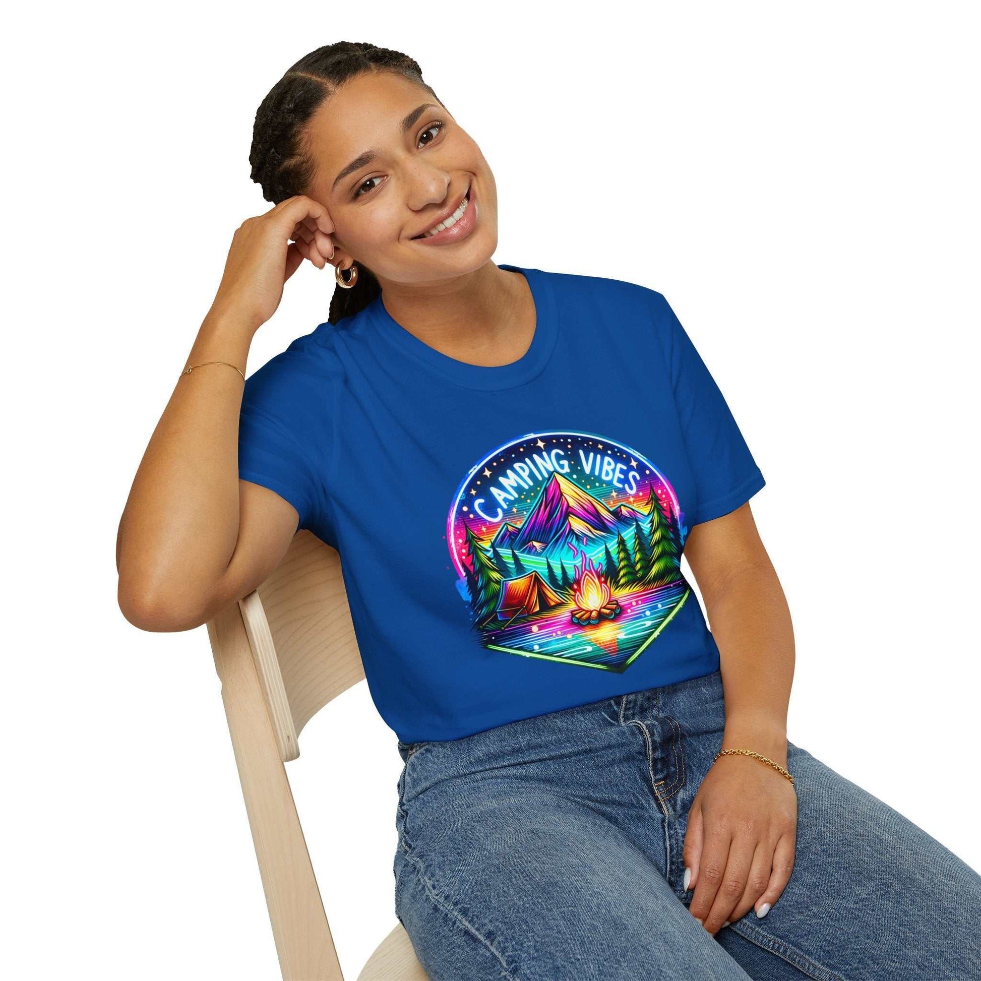 Woman wearing blue Camping Vibes Unisex Softstyle T-Shirt with colorful camping graphic sitting on chair