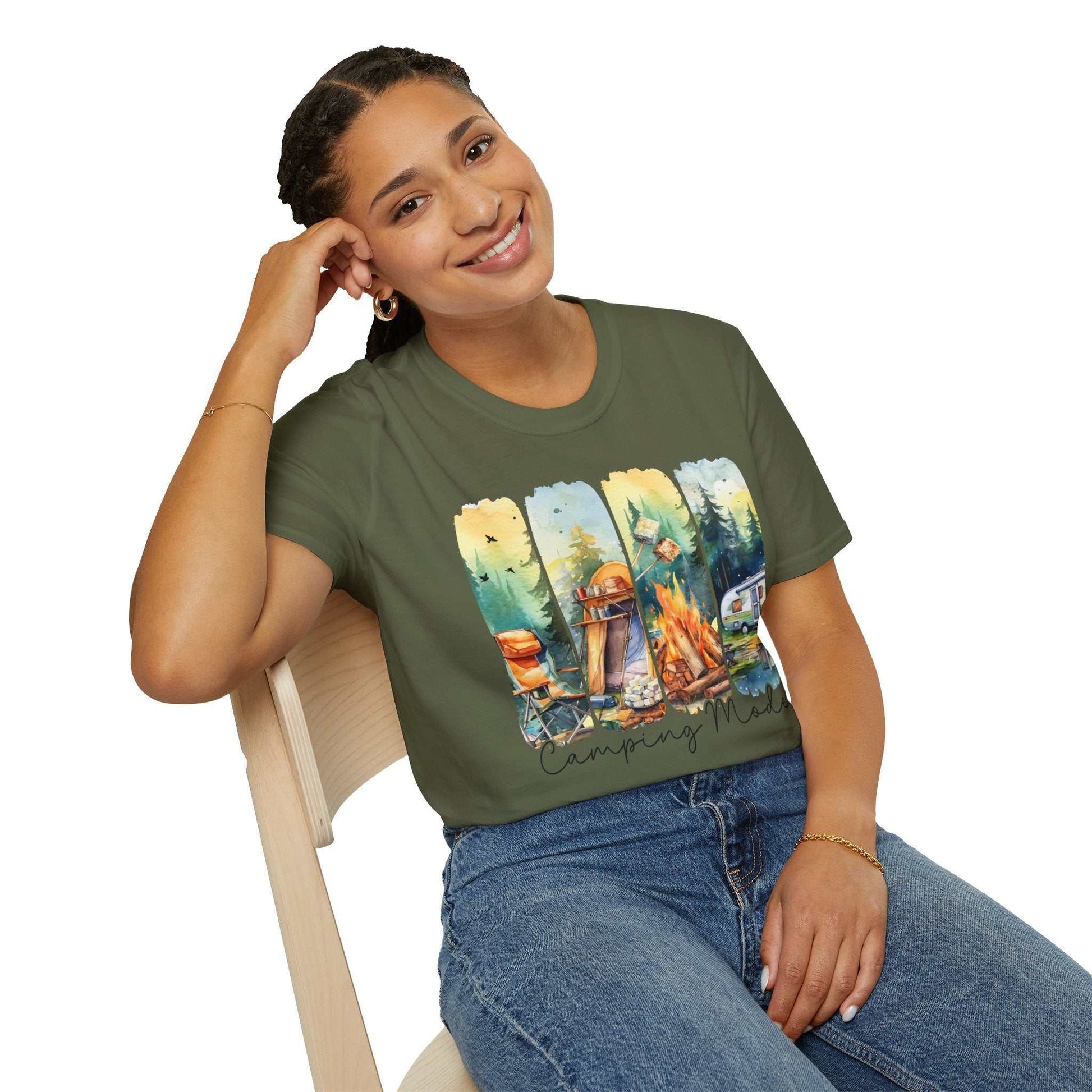 Woman wearing olive green Camping Adventure Unisex T-Shirt with camping-themed graphic sitting on wooden chair