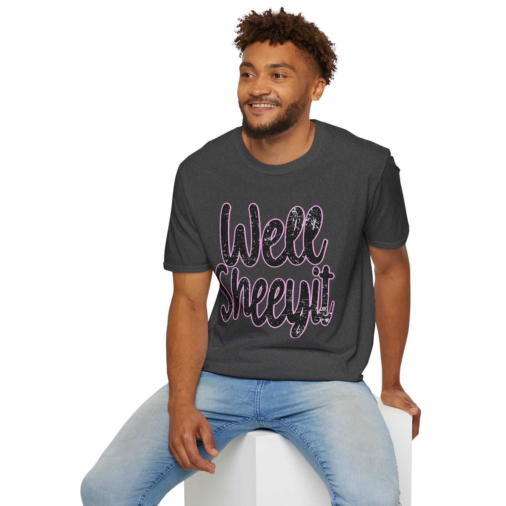 Man wearing casual black statement tee with "Well Sheeyit" funny quote, paired with light blue jeans, sitting and smiling