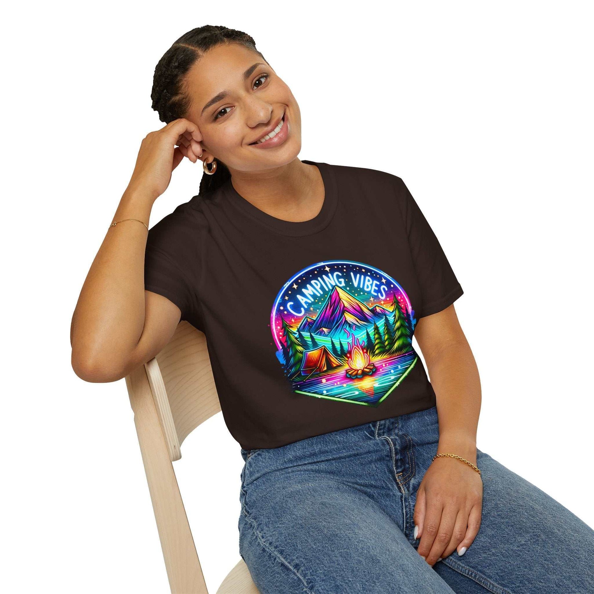Woman wearing black Camping Vibes Unisex Softstyle T-shirt with colorful camping scene graphic.