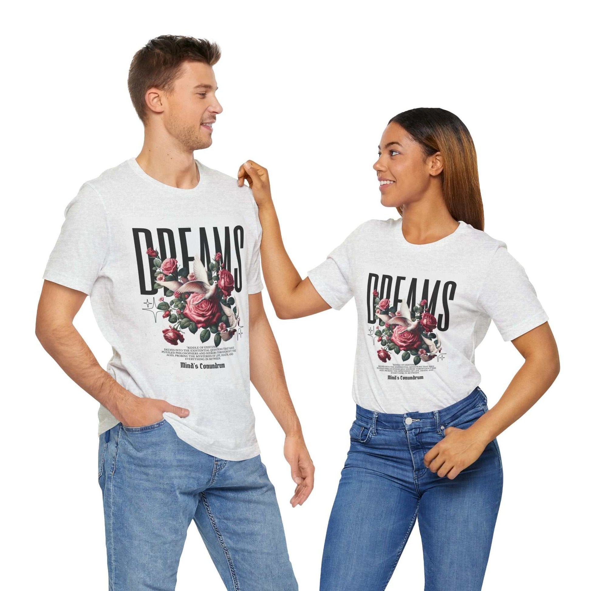 Couple wearing white Dreams Floral Tee with floral graphic and bold text, paired with casual jeans, smiling at each other.