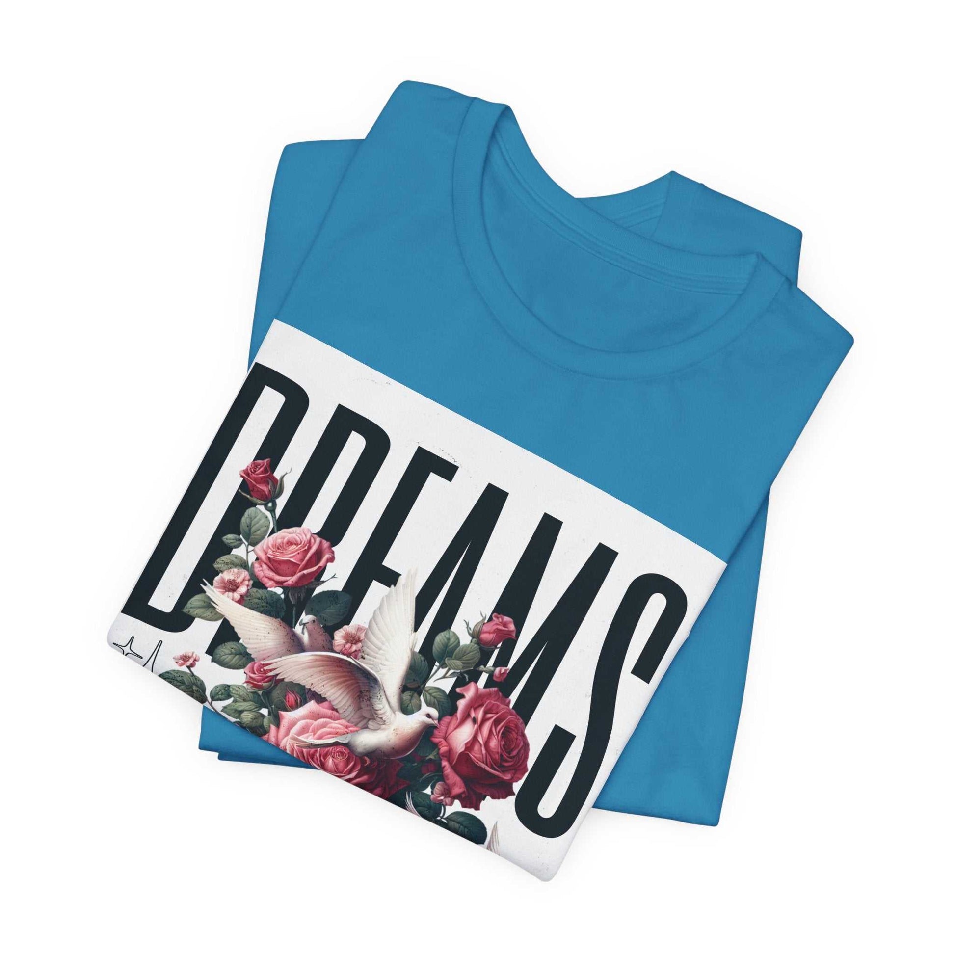 Folded blue Dreams Floral Tee with floral and bird graphic and bold text design