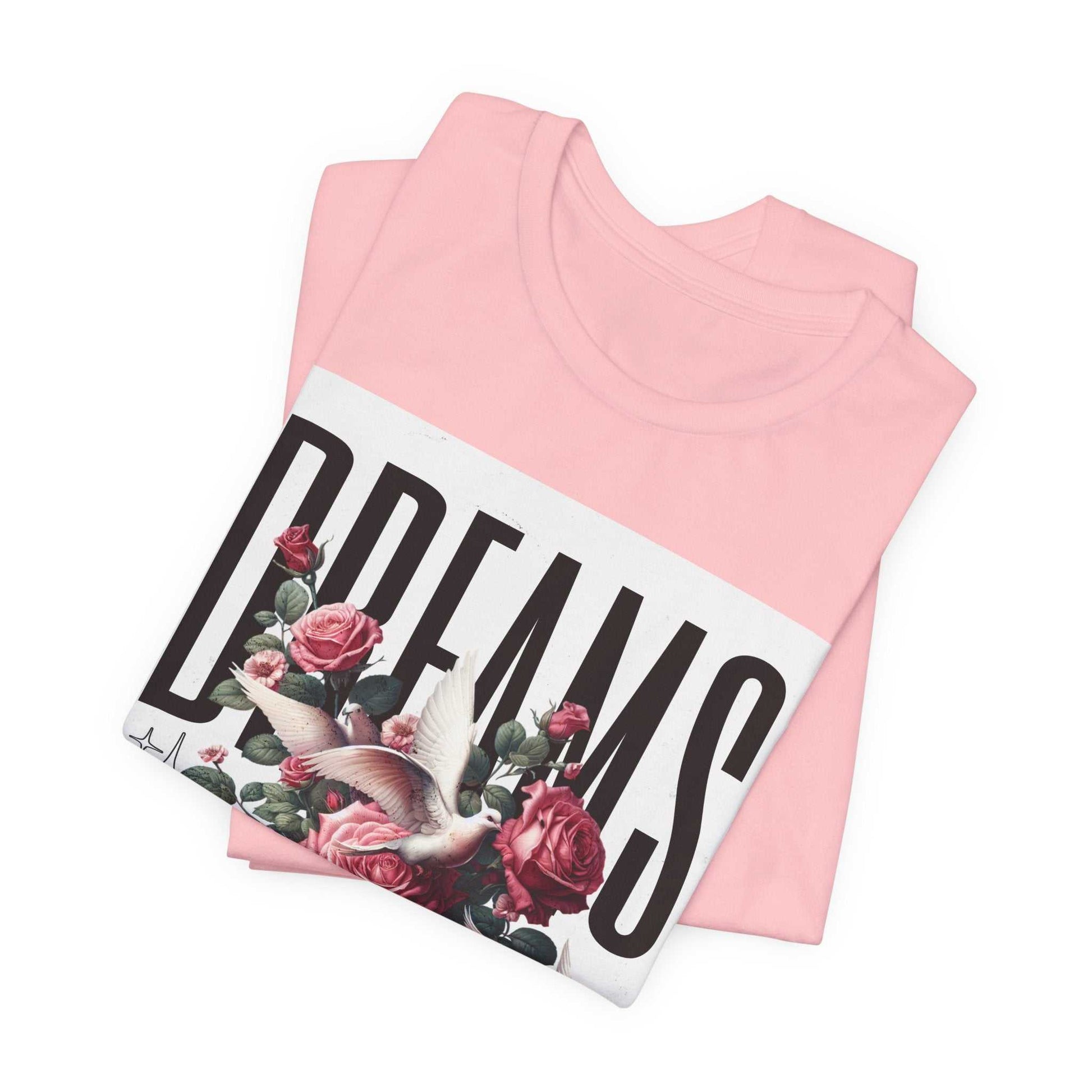 Pink Dreams Floral Tee with bold typography, floral design, and a white rectangular background, folded flat